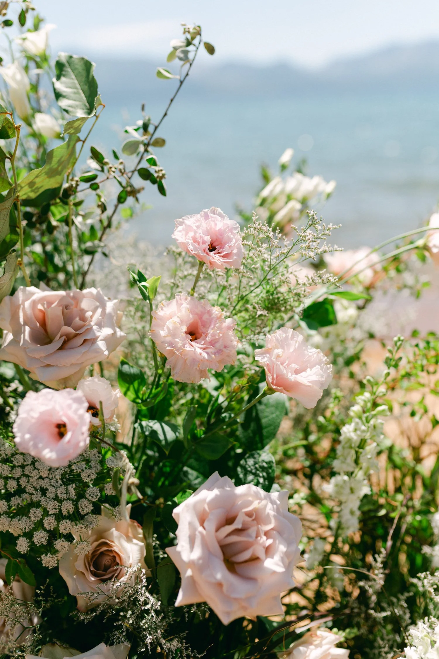 Lake Tahoe 4-H Camp wedding photos, photo of floral arrangement featuring soft pink roses for a romantic wedding ceremony backdrop.