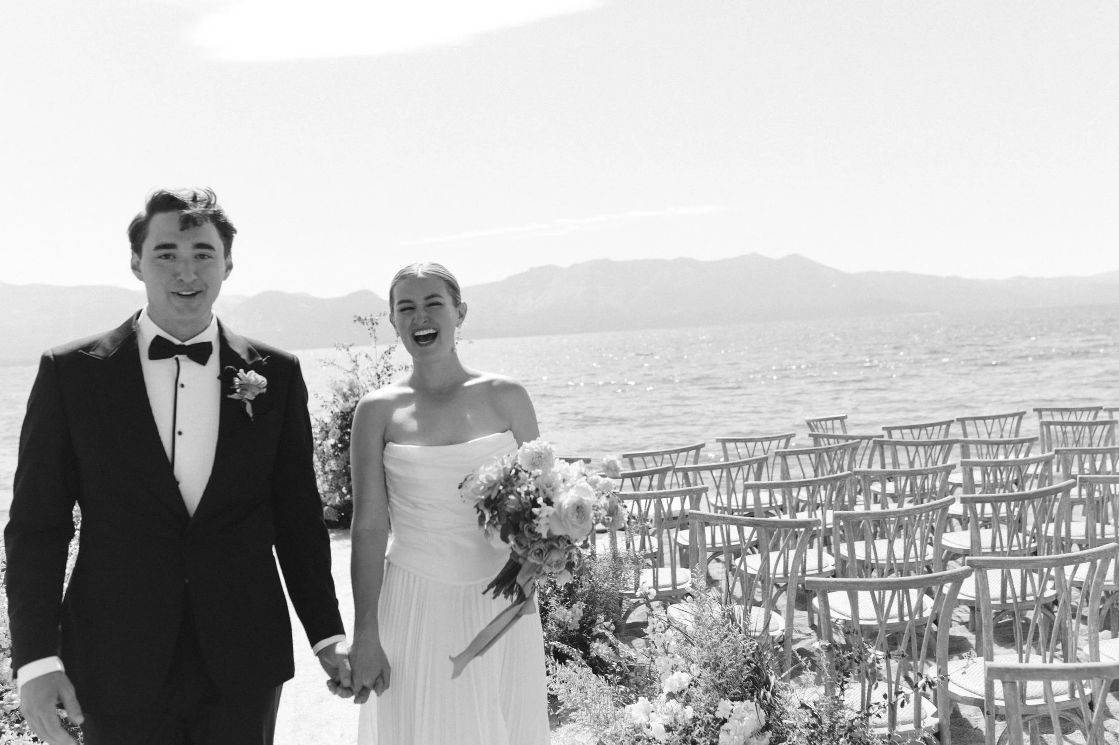 Lake Tahoe 4-H Camp wedding photos, photo of the newlywed couple smiling joyfully beside a calm lake 