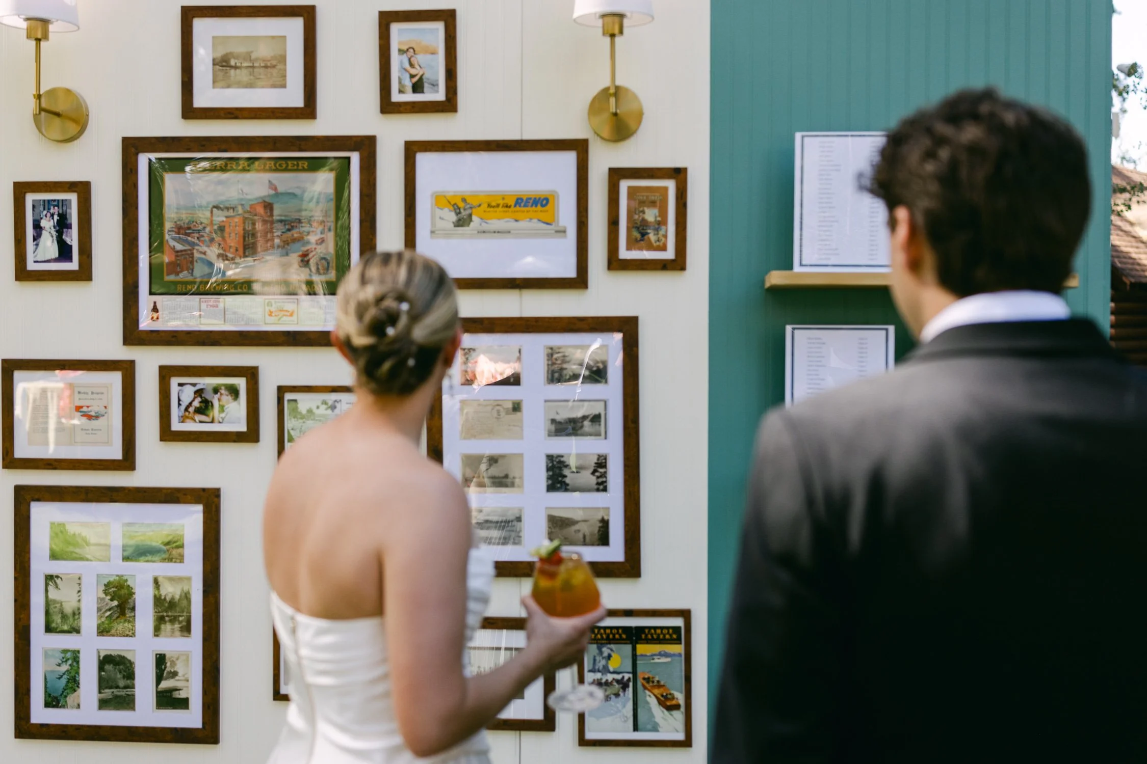 Lake Tahoe 4-H Camp wedding photos, photo of the newlywed couple looking at a wedding seating chart photo wall with vintage decor
