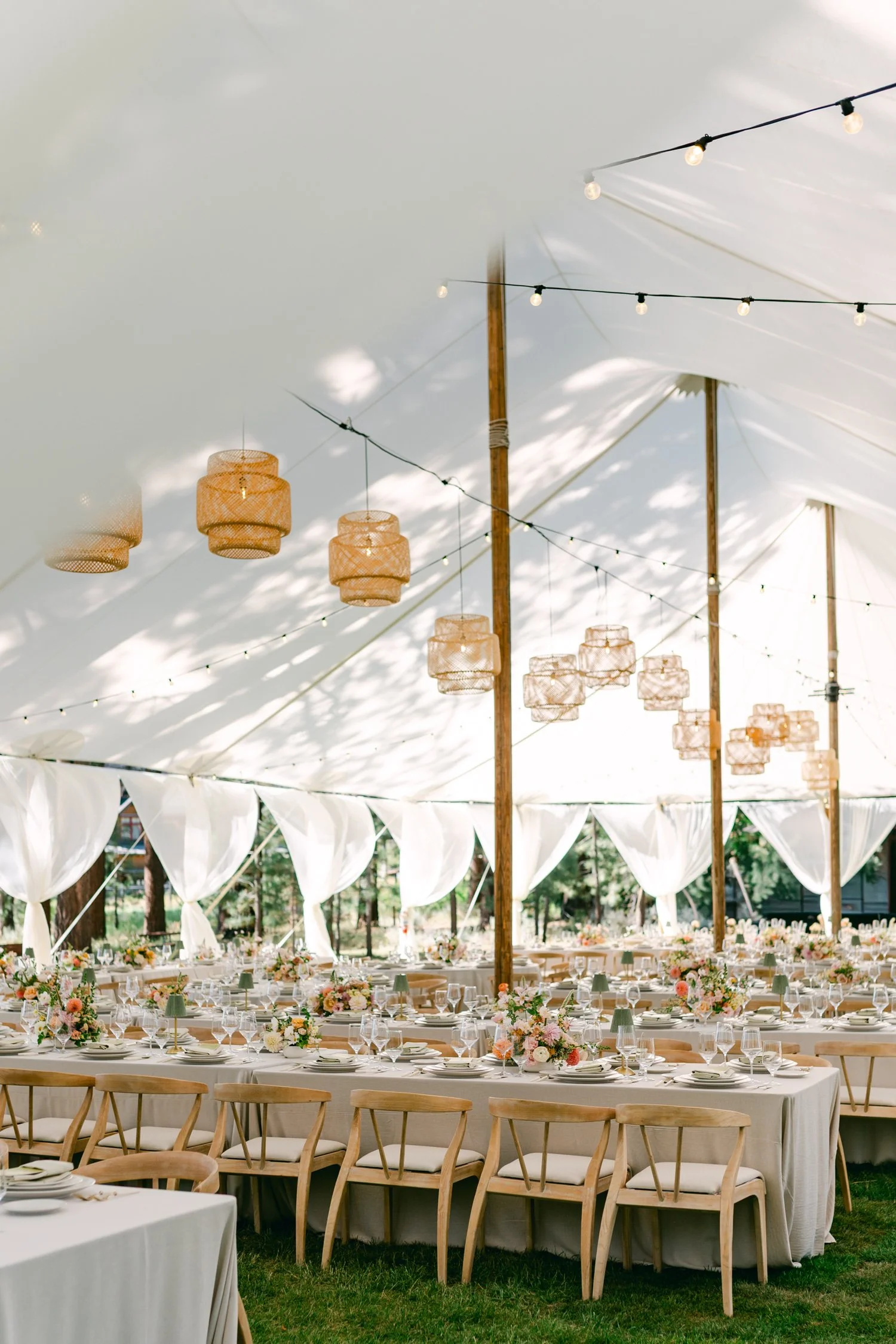Lake Tahoe 4-H Camp wedding photos, photo of an outdoor wedding reception setup decorated with woven basket lanterns and string lighting.
