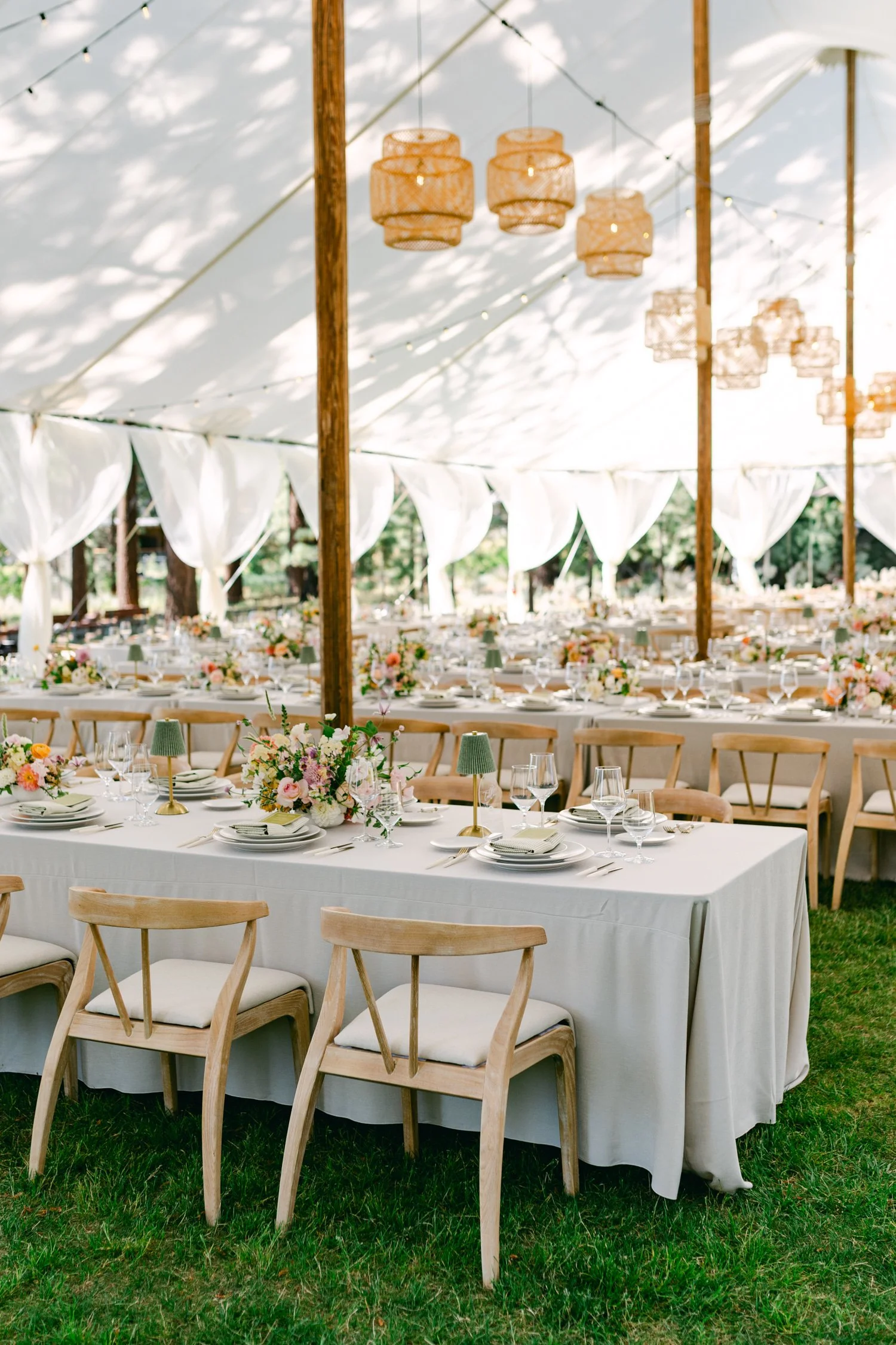 Lake Tahoe 4-H Camp wedding photos, photo of a tented wedding reception styled with natural wood chairs and white fabric draping
