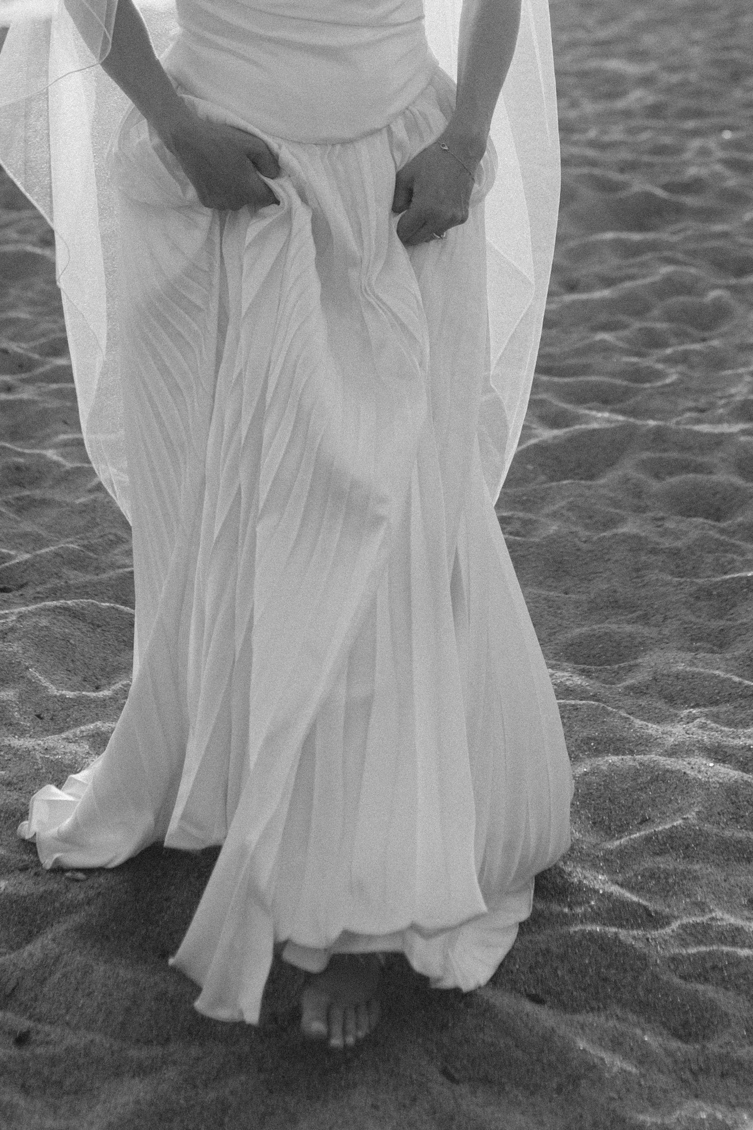 Lake Tahoe 4-H Camp wedding photos, photo of the bride in a white, floor-length gown featuring vertical pleats and a flowing silhouette perfect for a beach setting