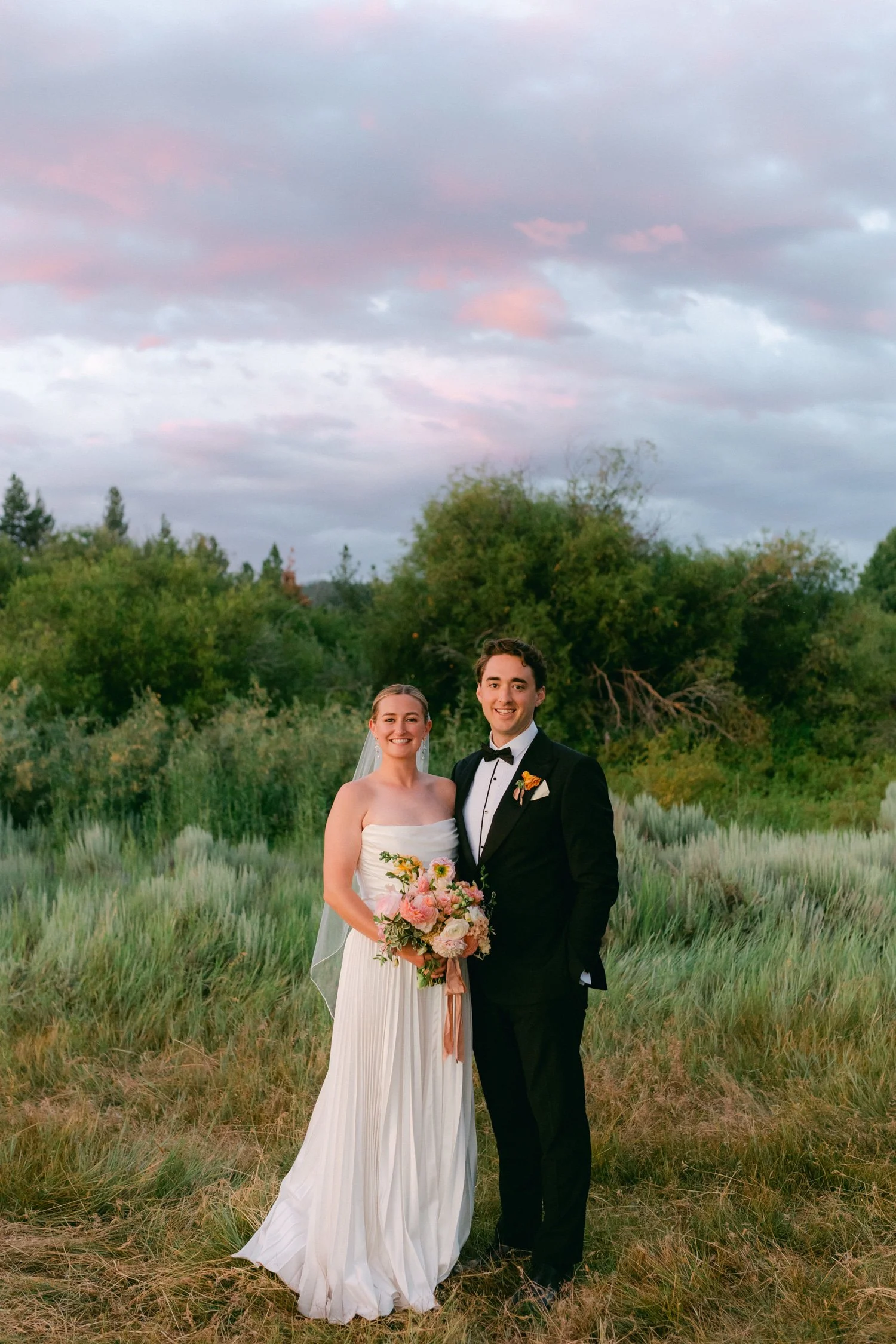 Lake Tahoe 4-H Camp wedding photos, photo of the newlywed couple posing in a field at sunset