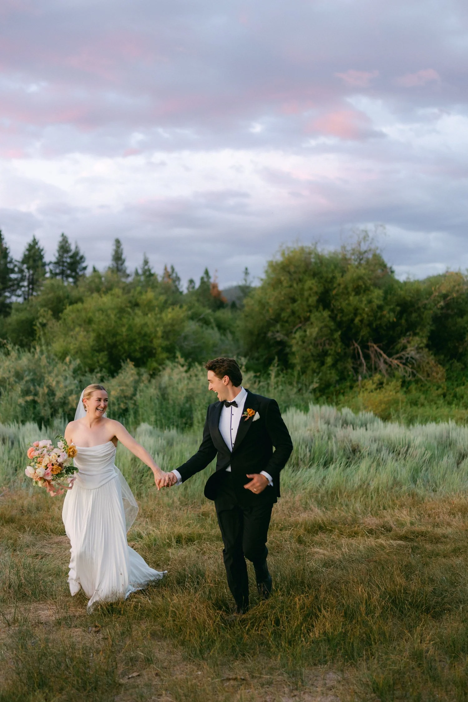 Lake Tahoe 4-H Camp wedding photos, photo of the couple running through a rustic field at sunset