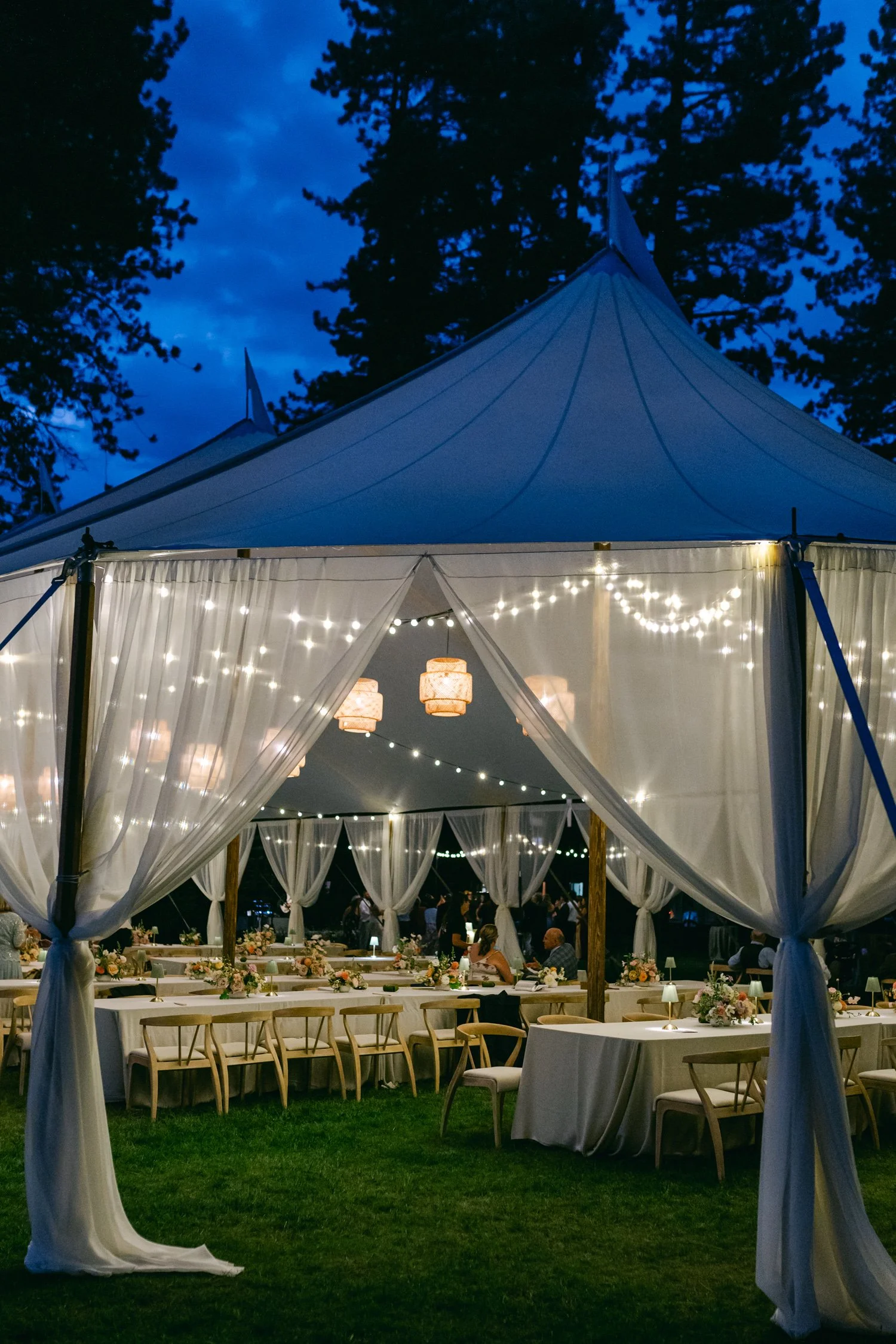 Lake Tahoe 4-H Camp wedding photos, photo of a white sailcloth tent styled with elegant draped lighting and sheer fabric panels creating a classic outdoor reception venue