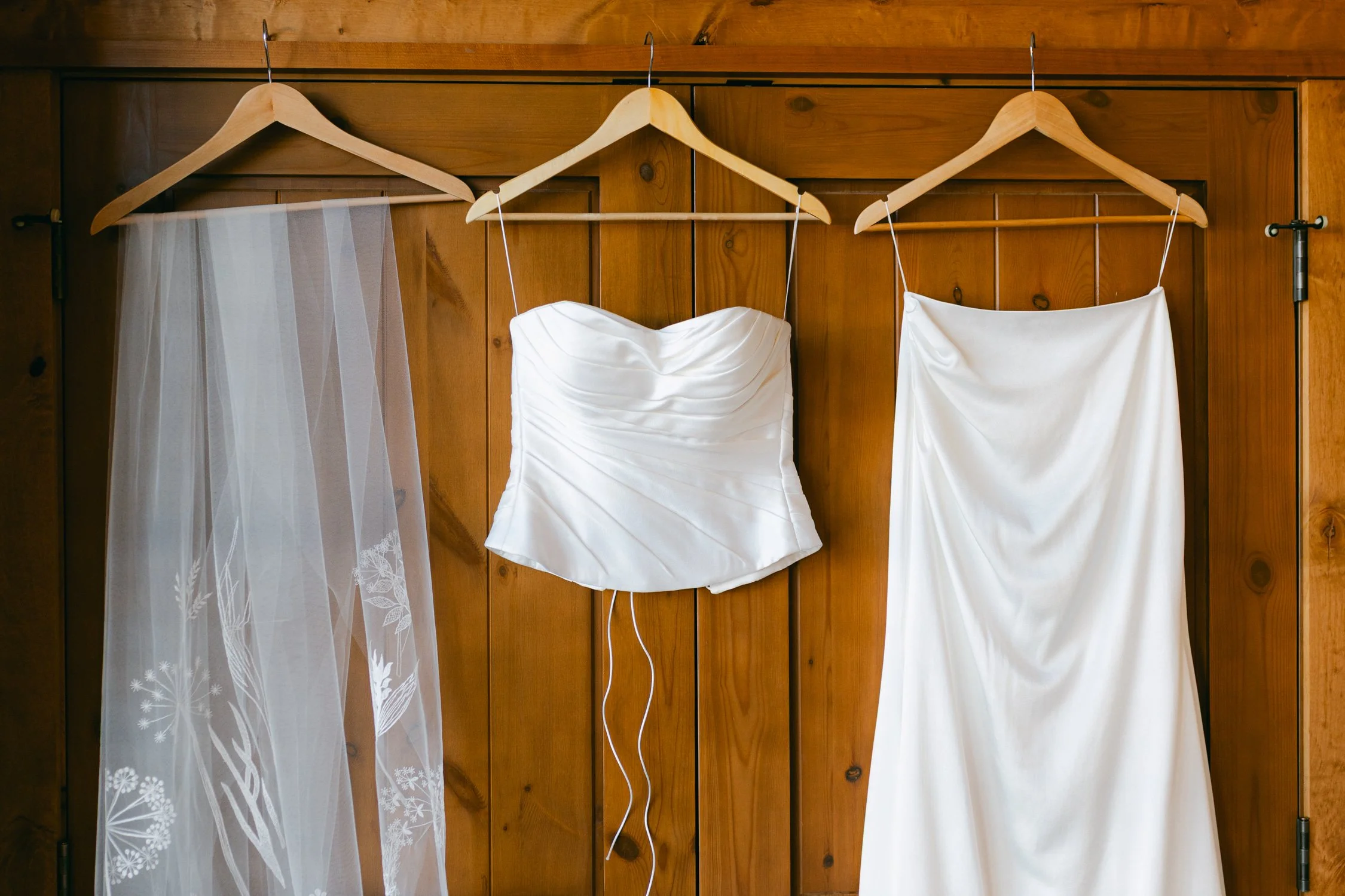 Zephyr Lodge wedding, photo of bridal outfit consists of a draped strapless top and a matching skirt, paired with a veil featuring delicate embroidered foliage details