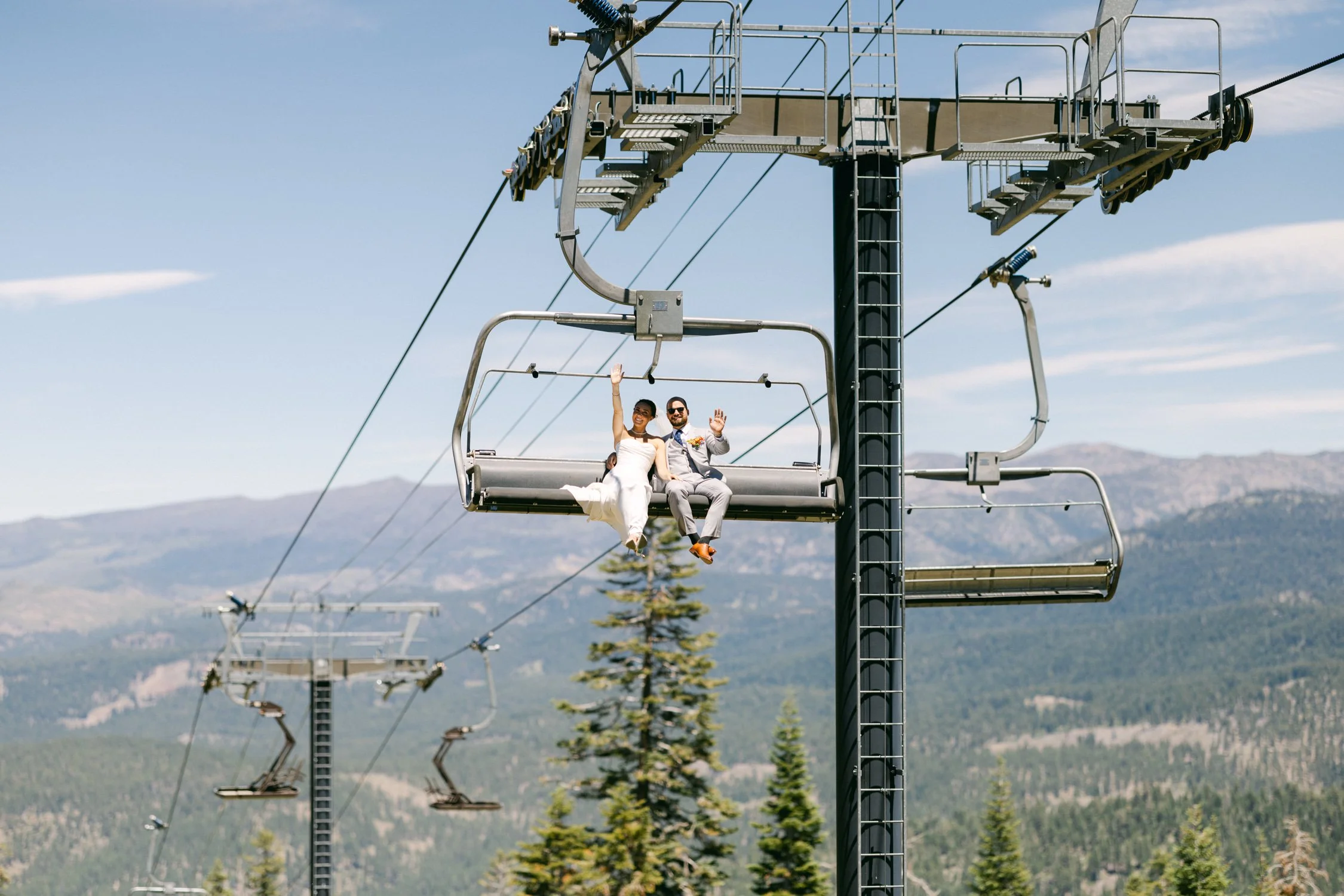 Zephyr Lodge wedding, photo of the bride and groom waving from a chairlift at a mountain resort