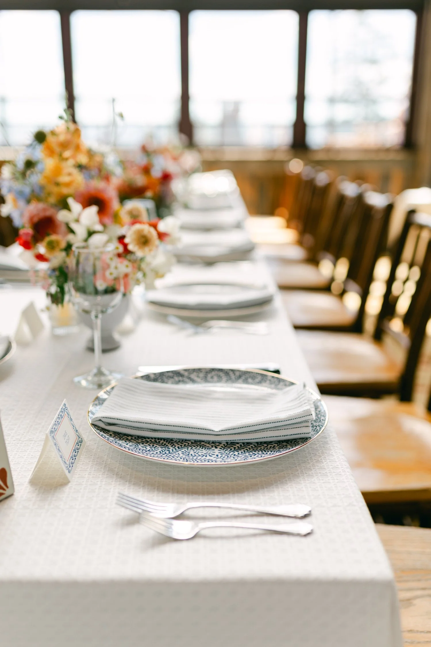 Zephyr Lodge wedding, photo of a beautifully set wedding reception table featuring blue patterned plates and vibrant floral arrangements
