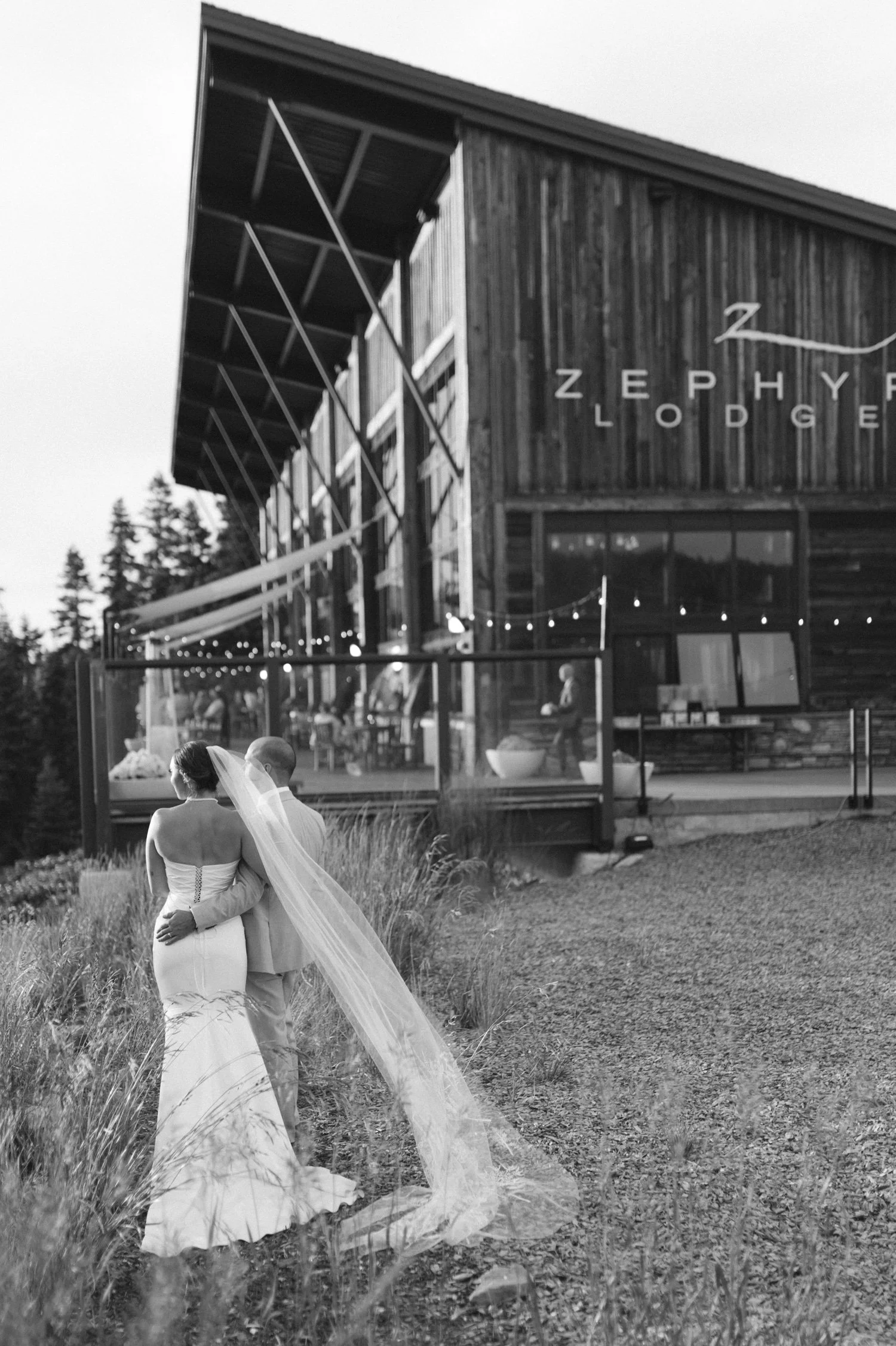 Zephyr Lodge wedding, photo of the newlywed couple standing outside featuring rustic wooden architecture