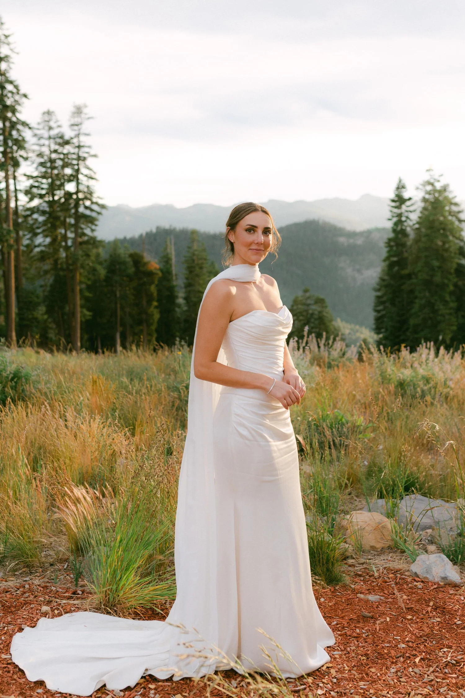 Zephyr Lodge wedding, photo of the bride in a strapless ivory satin bridal gown with a draped bodice and a long, flowing cape-style veil