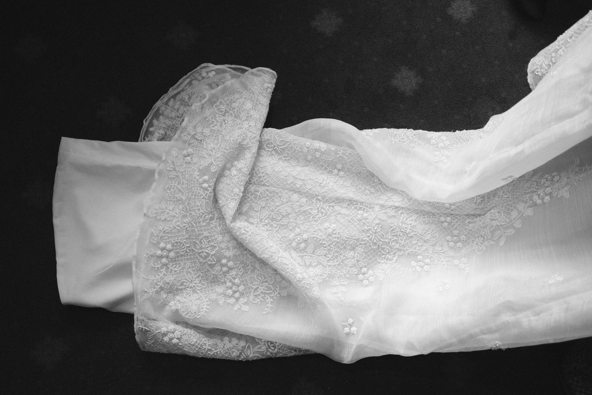 A Valhalla Lake Tahoe Wedding, photo of a delicate white lace wedding dress featuring intricate floral embroidery 
