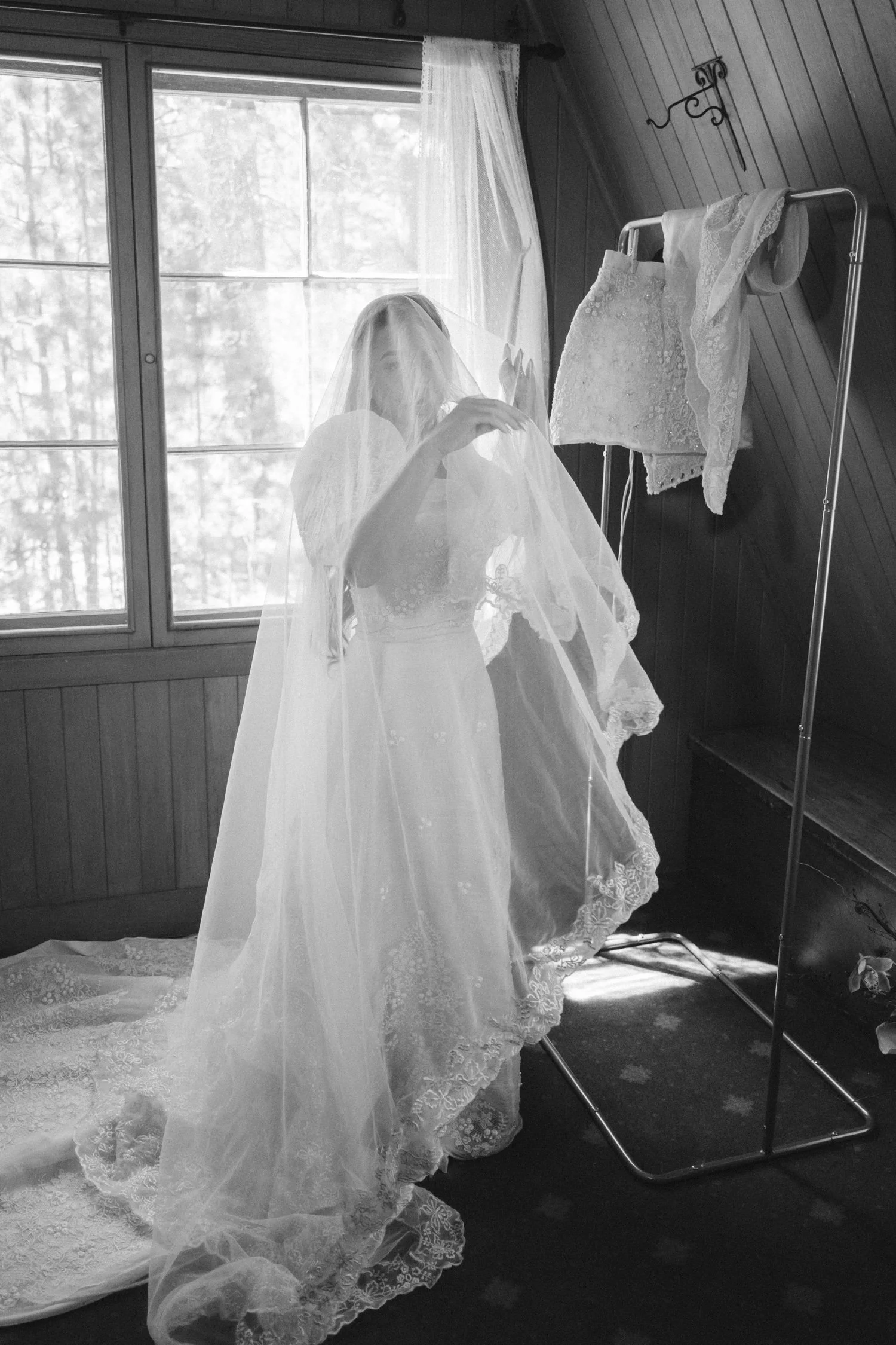 A Valhalla Lake Tahoe Wedding, photo of the bride in a long, lace-trimmed tulle wedding veil in front of a window.