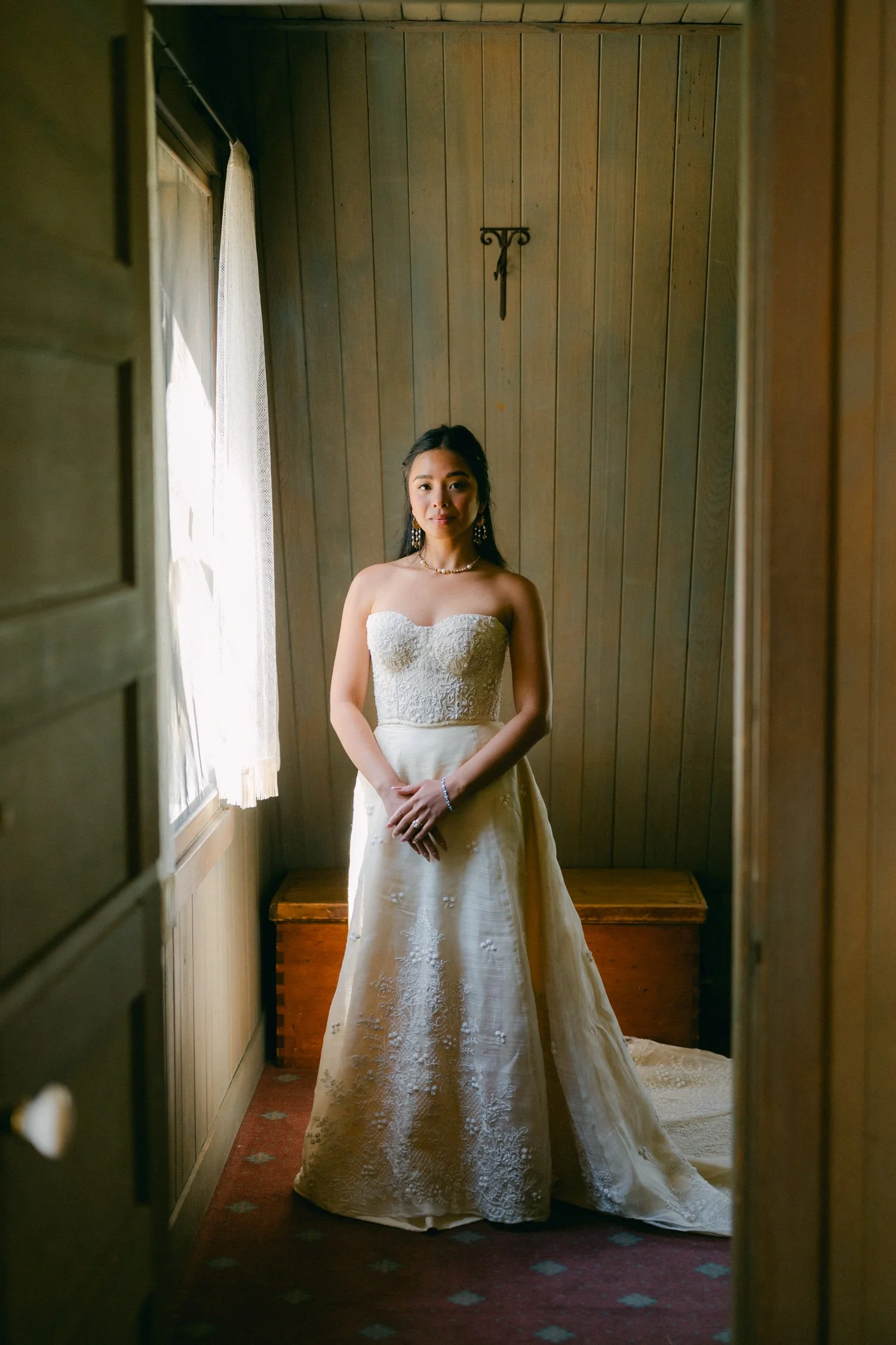 A Valhalla Lake Tahoe Wedding, photo of an elegant strapless wedding gown with a heavily textured, beaded sweetheart bodice and a flowing satin-like skirt.