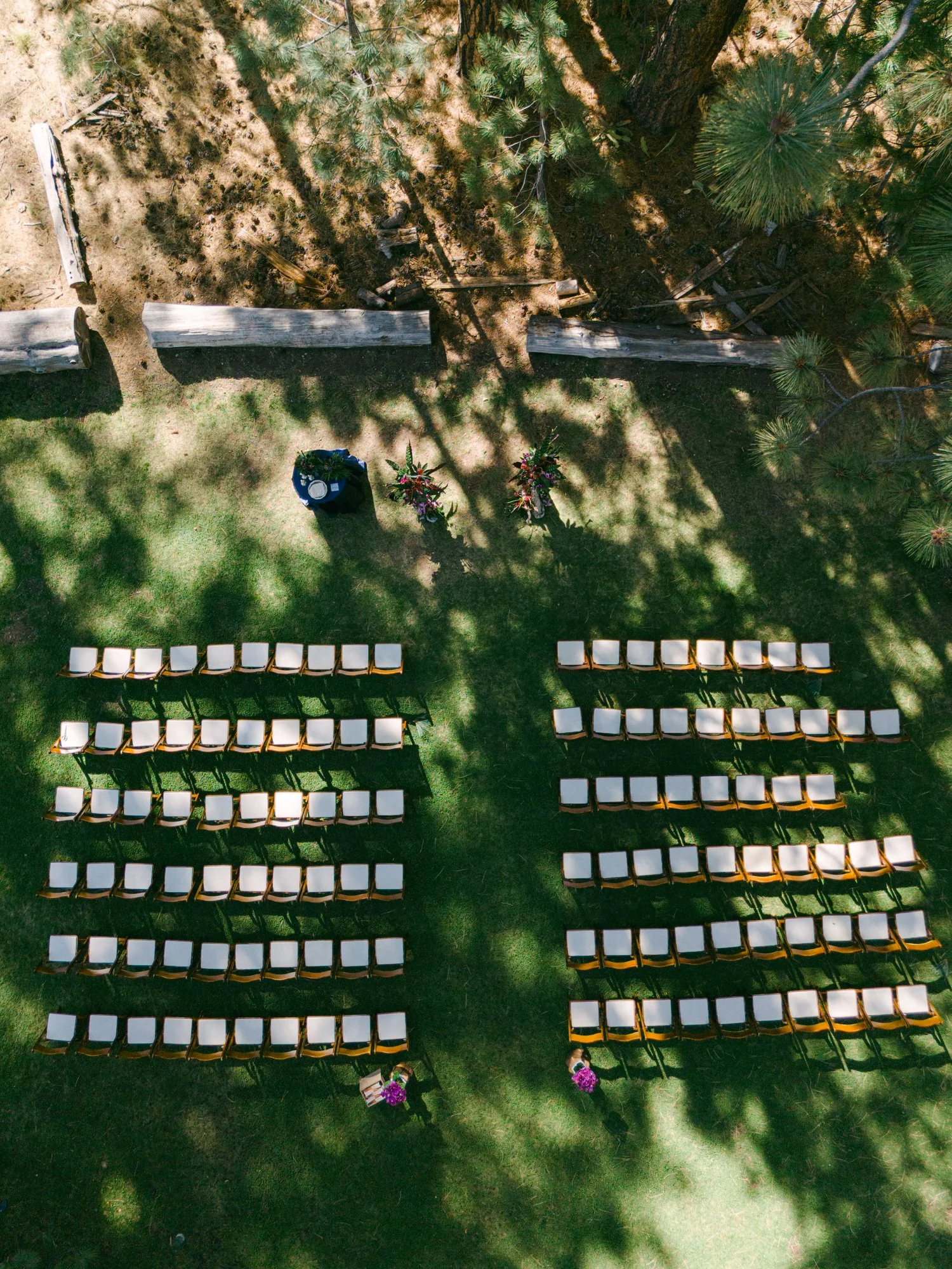 A Valhalla Lake Tahoe Wedding, photo of an overhead view shows an outdoor wedding ceremony setup with rows of chairs on a grassy lawn surrounded by trees.