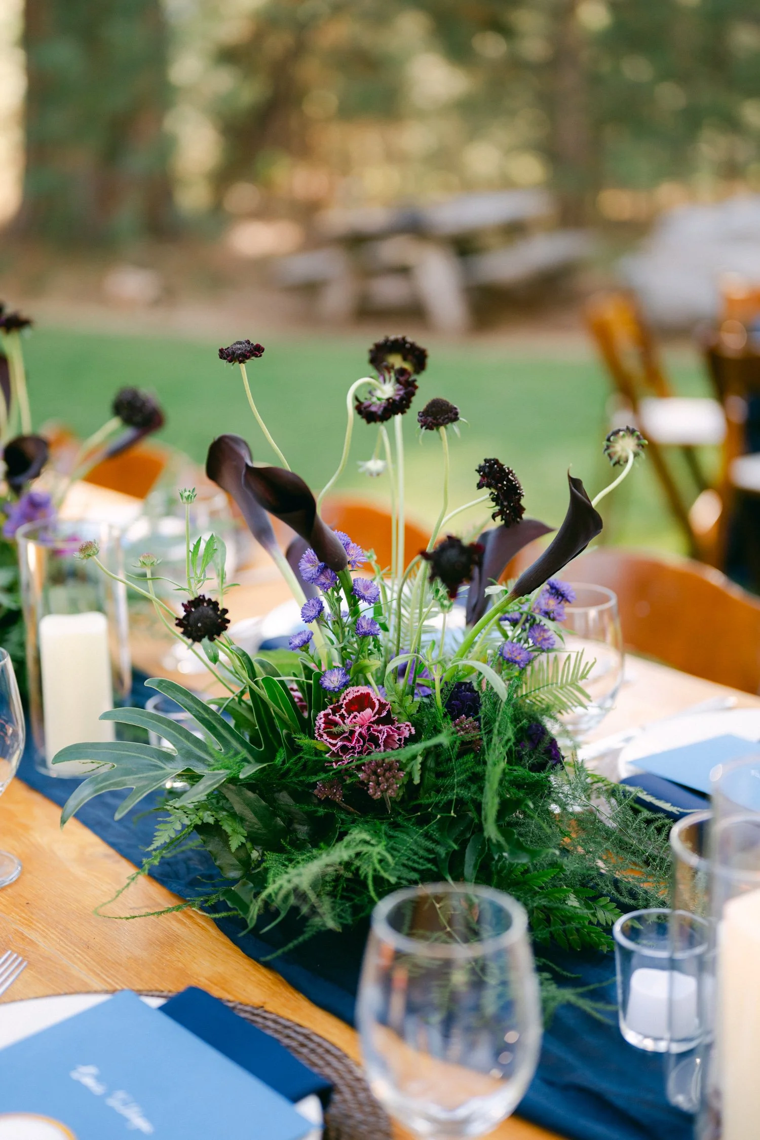A Valhalla Lake Tahoe Wedding, photo of moody outdoor wedding tablescape accented with dark calla lilies, scabiosa, and vibrant greenery.