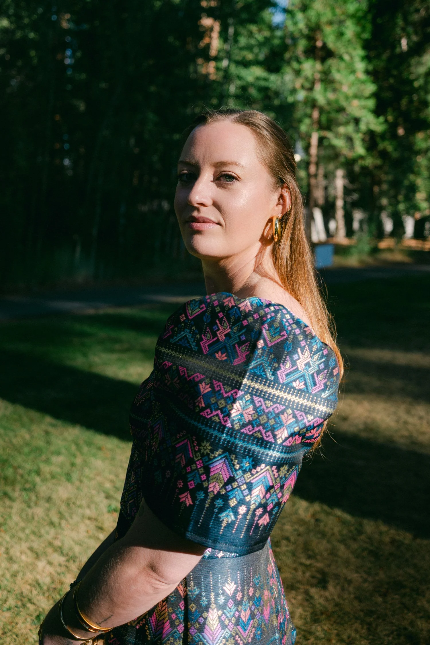 A Valhalla Lake Tahoe Wedding, photo of a wedding guest a modern Filipiniana dress crafted from a colorful, handwoven fabric with traditional geometric patterns and distinctive short puff sleeves