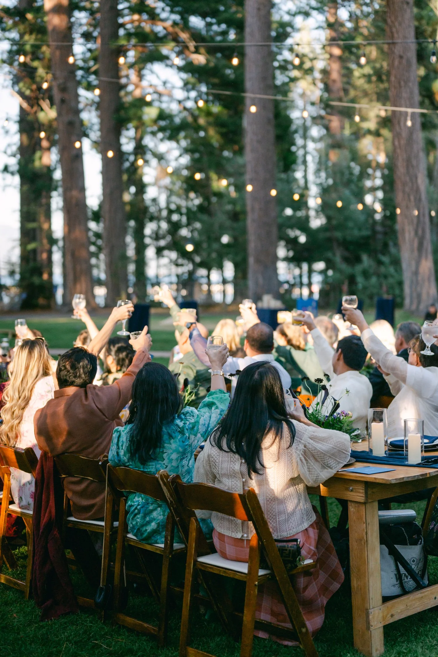 A Valhalla Lake Tahoe Wedding, photo of outdoor reception dinner set among tall pine trees during twilight.