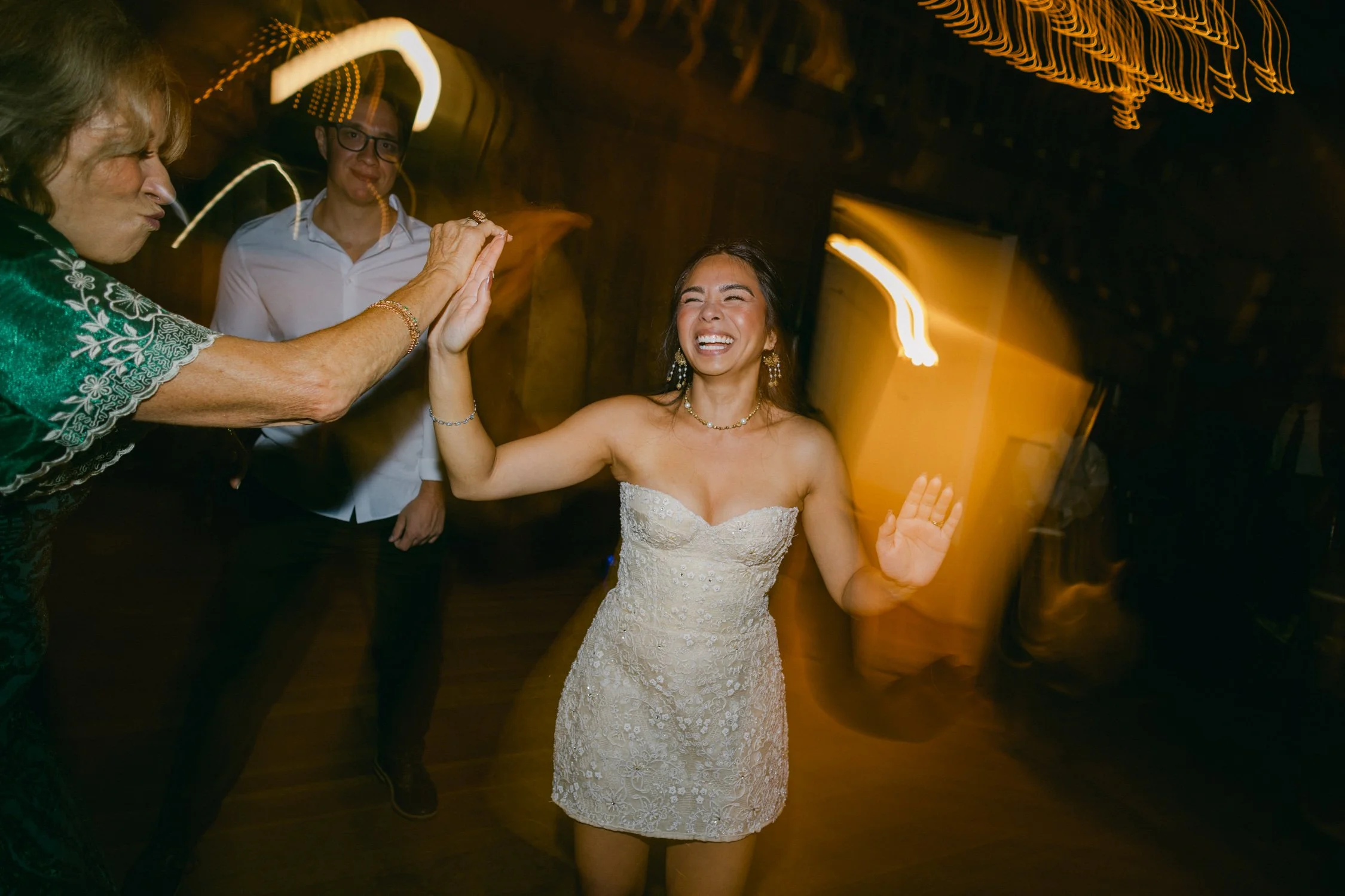 A Valhalla Lake Tahoe Wedding, photo of captures a joyful wedding reception dance floor with guests celebrating around the bride.