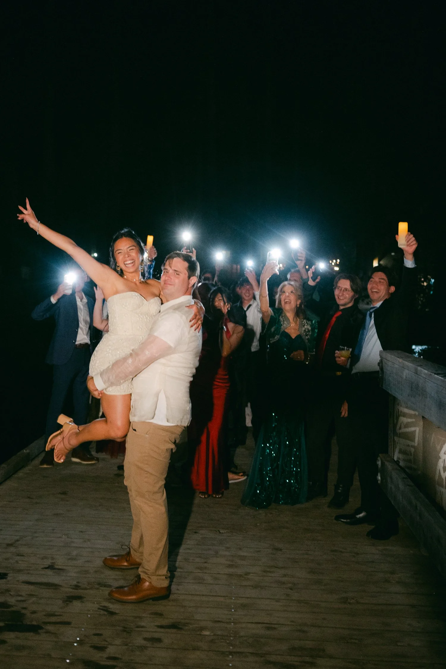 A Valhalla Lake Tahoe Wedding, photo of a joyful wedding celebration at night on a wooden deck