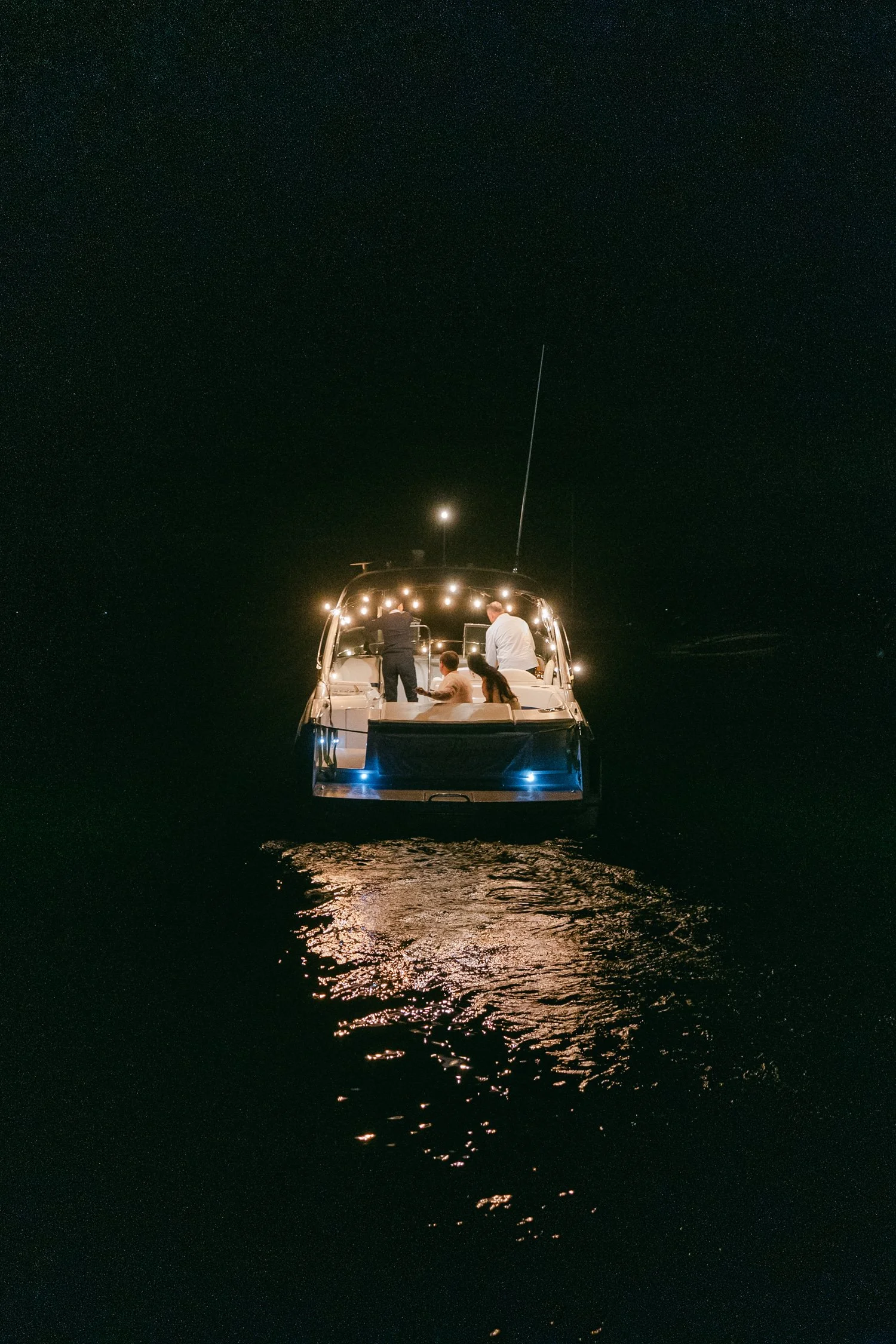 A Valhalla Lake Tahoe Wedding, photo of the newlywed leaving in an illuminated motor yacht cruising on the water at night