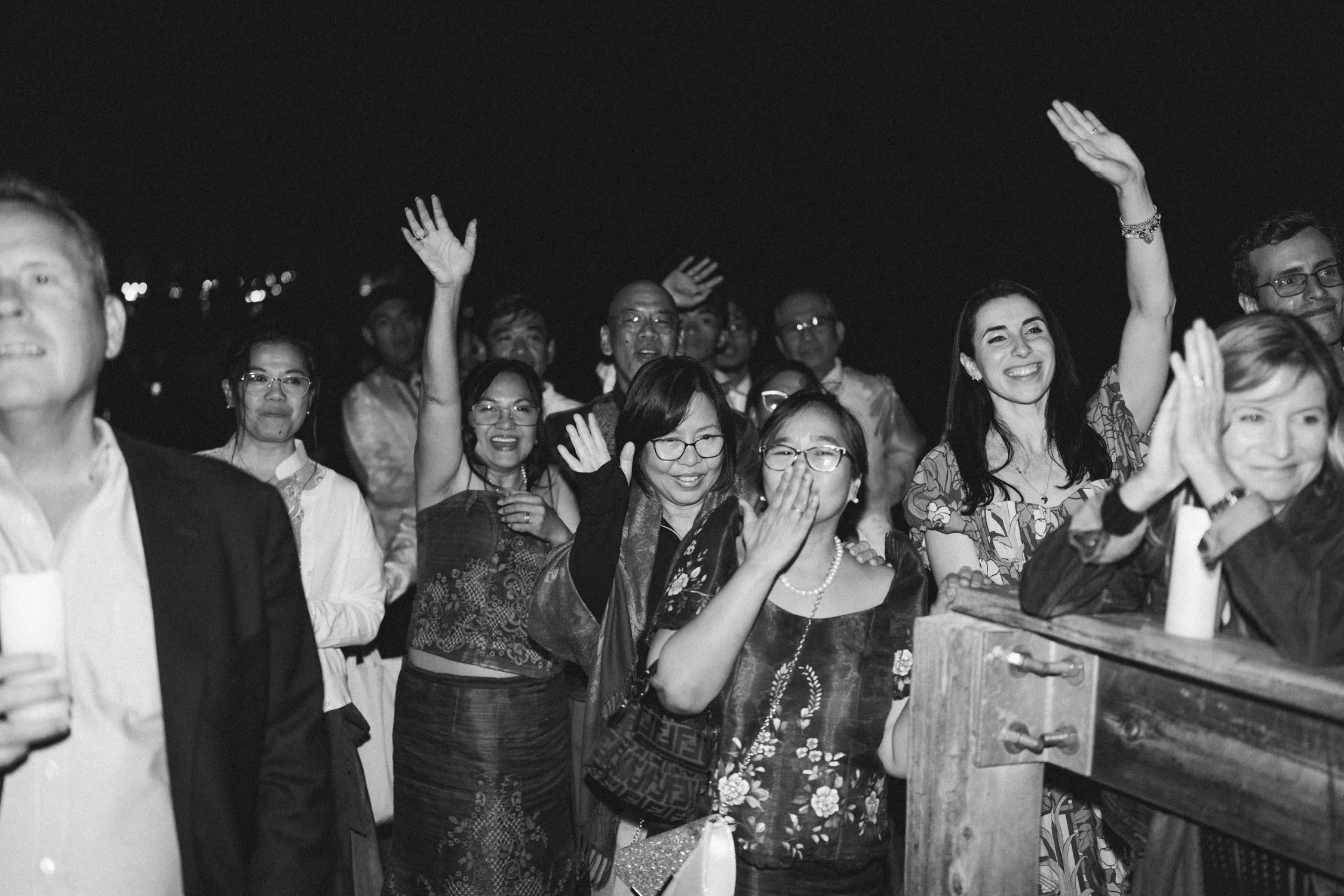 A Valhalla Lake Tahoe Wedding, photo of a joyful crowd of wedding guests waving and reacting emotionally during an evening outdoor celebration