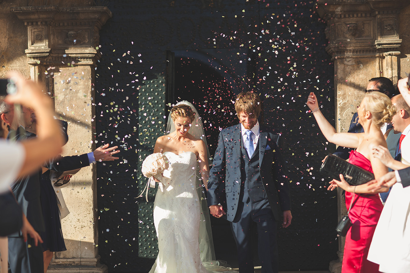 One of a set of images taken at this chic destination Wedding of Jenna & Nick. The stylish old town of Dubrovnik, Croatia.  Confetti is thrown at the beautiful couple.  Photography by Matt Porteous