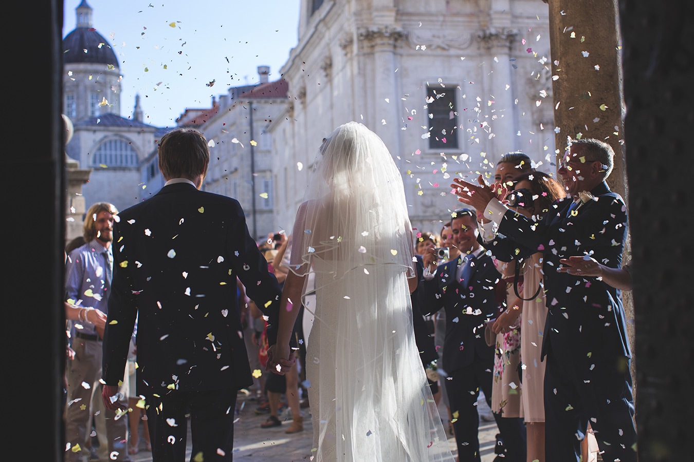 One of a set of images taken at this chic destination Wedding of Jenna & Nick. The stylish old town of Dubrovnik, Croatia.  Confetti is thrown over the couple.  photography by Matt Porteous