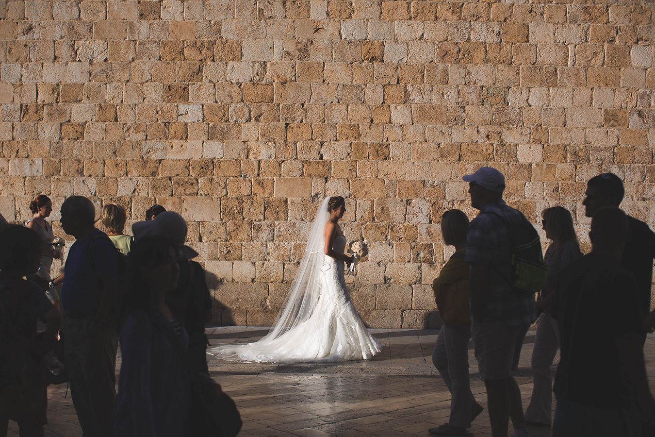 One of a set of images taken at this chic destination Wedding of Jenna & Nick. The stylish old town of Dubrovnik, Croatia.  The Bride walks down the street.  Photography by Matt Porteous