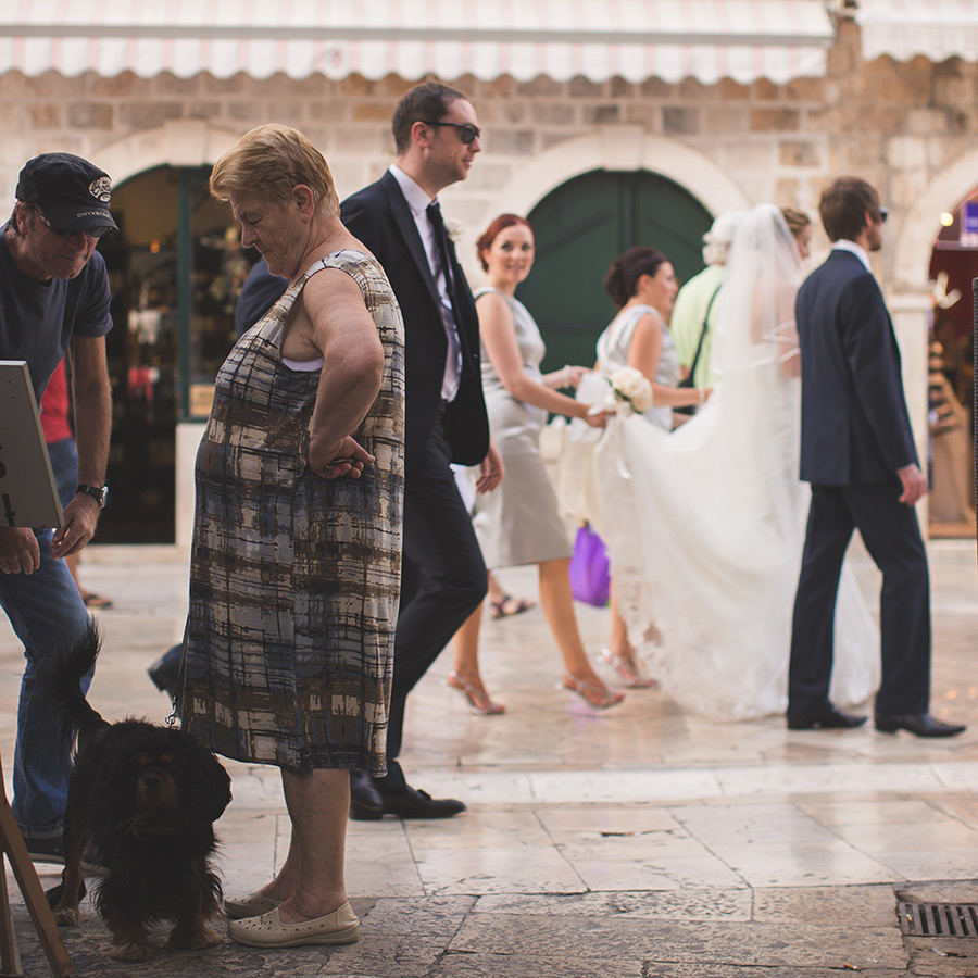One of a set of images taken at this chic destination Wedding of Jenna & Nick. The stylish old town of Dubrovnik, Croatia.  The bridesmaid lifts the train of the dress.  Photography by Matt Porteous