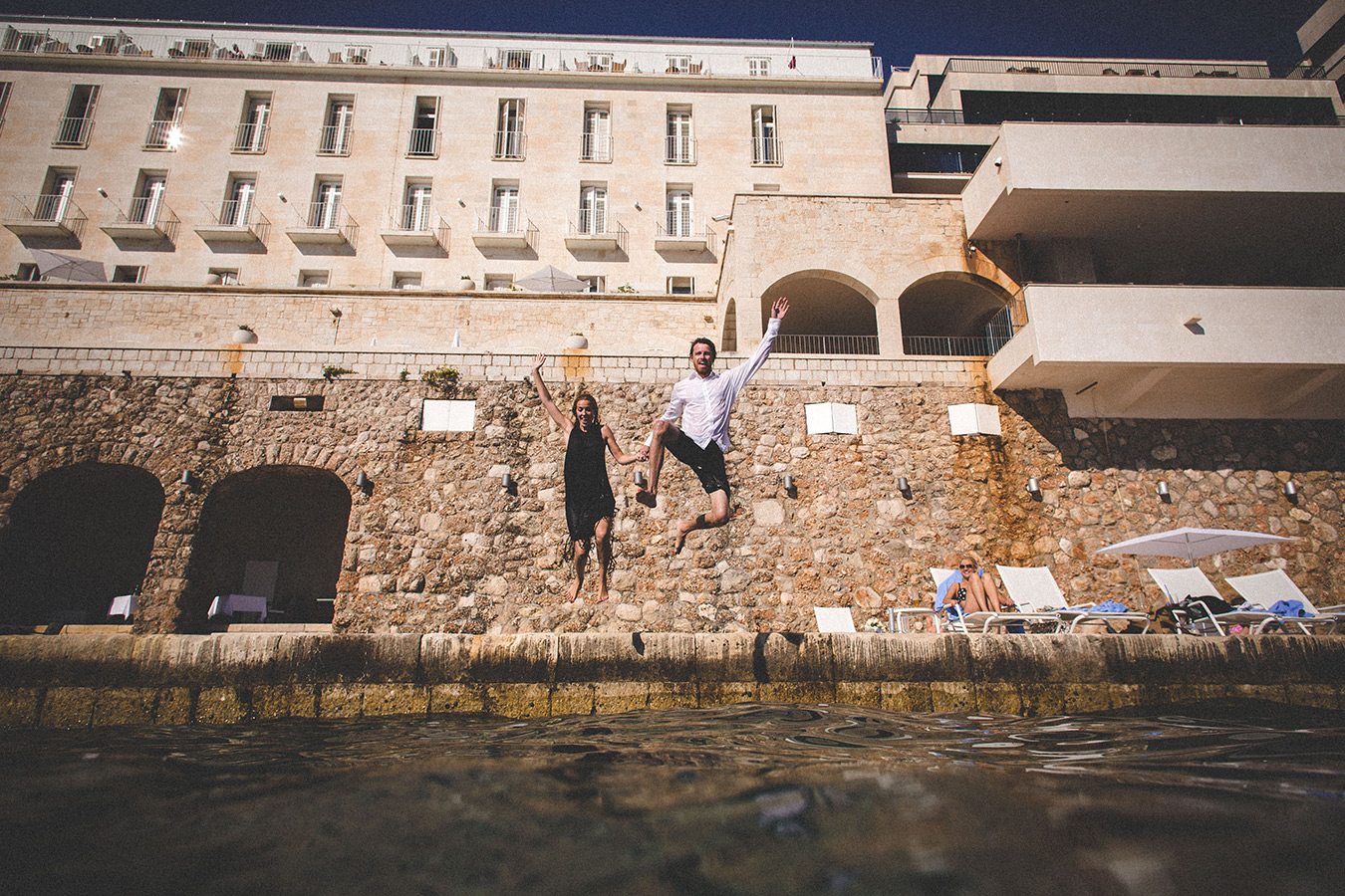 One of a set of images taken at this chic destination Wedding of Jenna & Nick. The stylish old town of Dubrovnik, Croatia.  The couple jump into the sea.  Photography by Matt Porteous