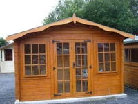Orange coloured wooden garden shed with glass windows.