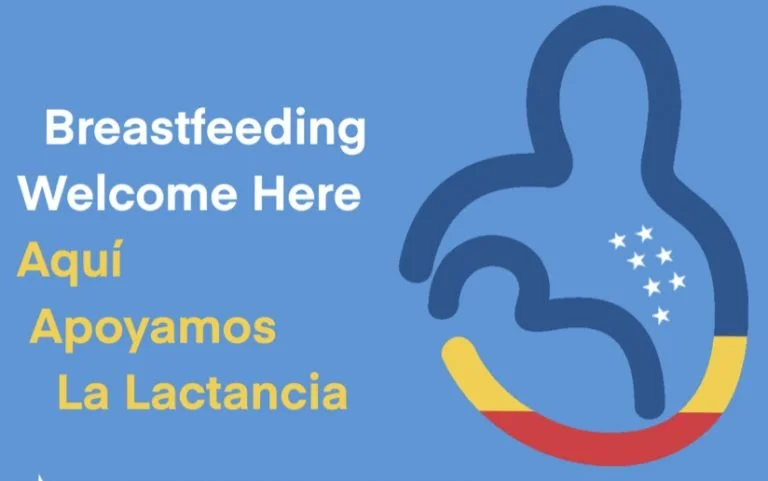 Sign promoting breastfeeding support in English and Spanish, showing a stylized person feeding an infant and stars, against a blue background.