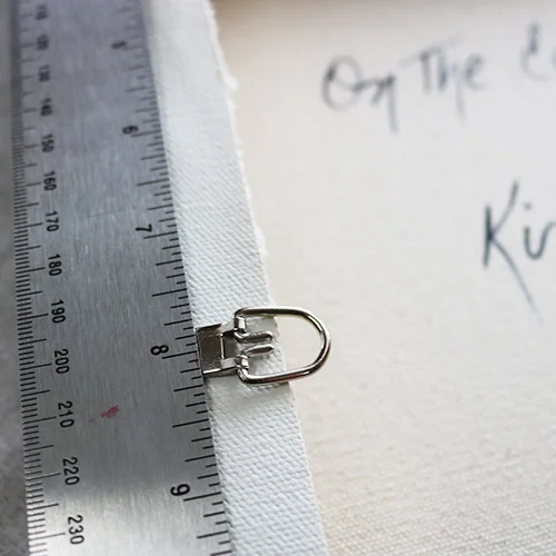 The D-ring should be placed about 1/3 of the way from the top, This canvas is is 24" long, so I've placed the D-ring 8" from the top.