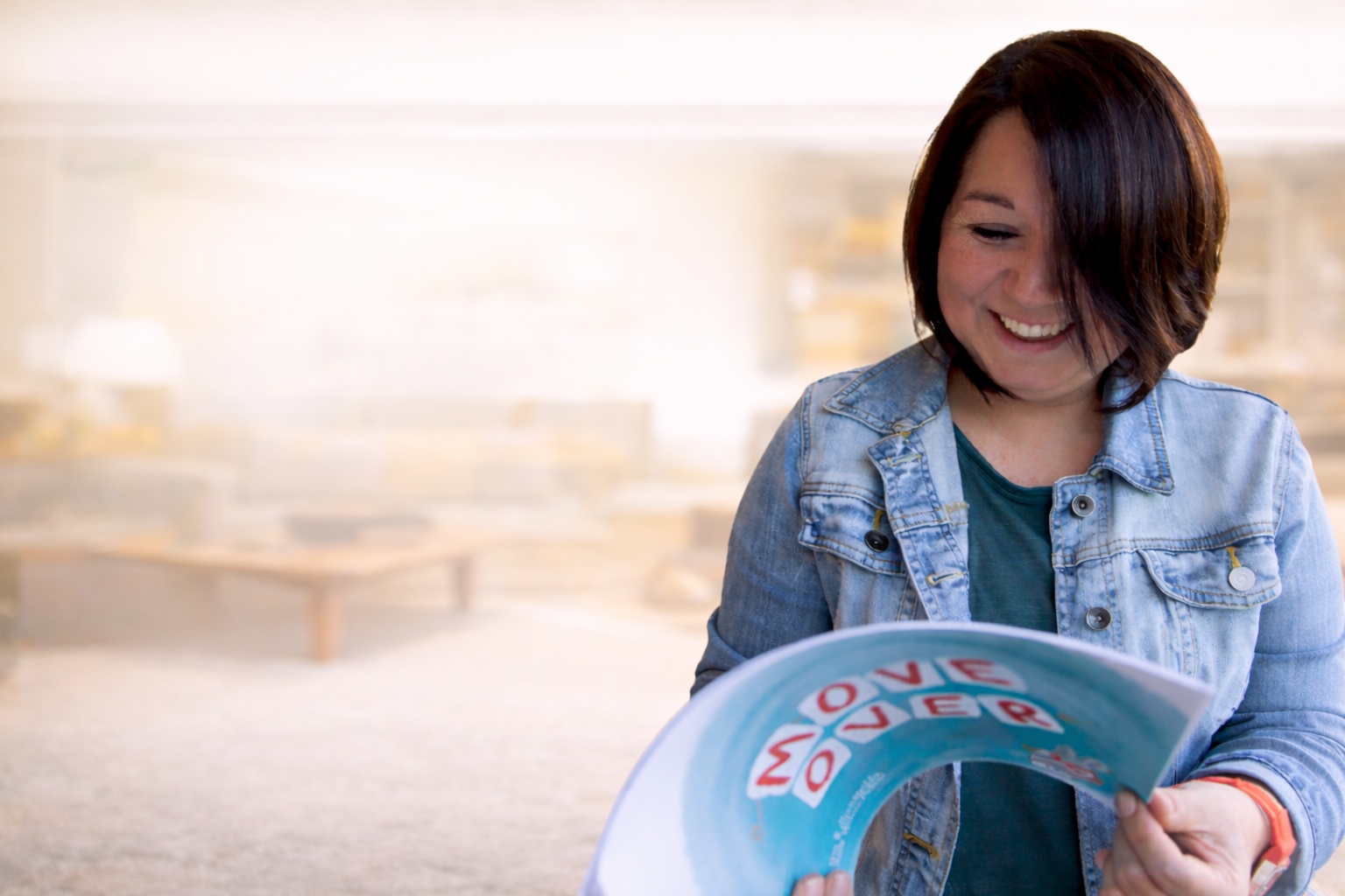 Michelle Pullins reading the children’s book Move Over in a cozy living room setting