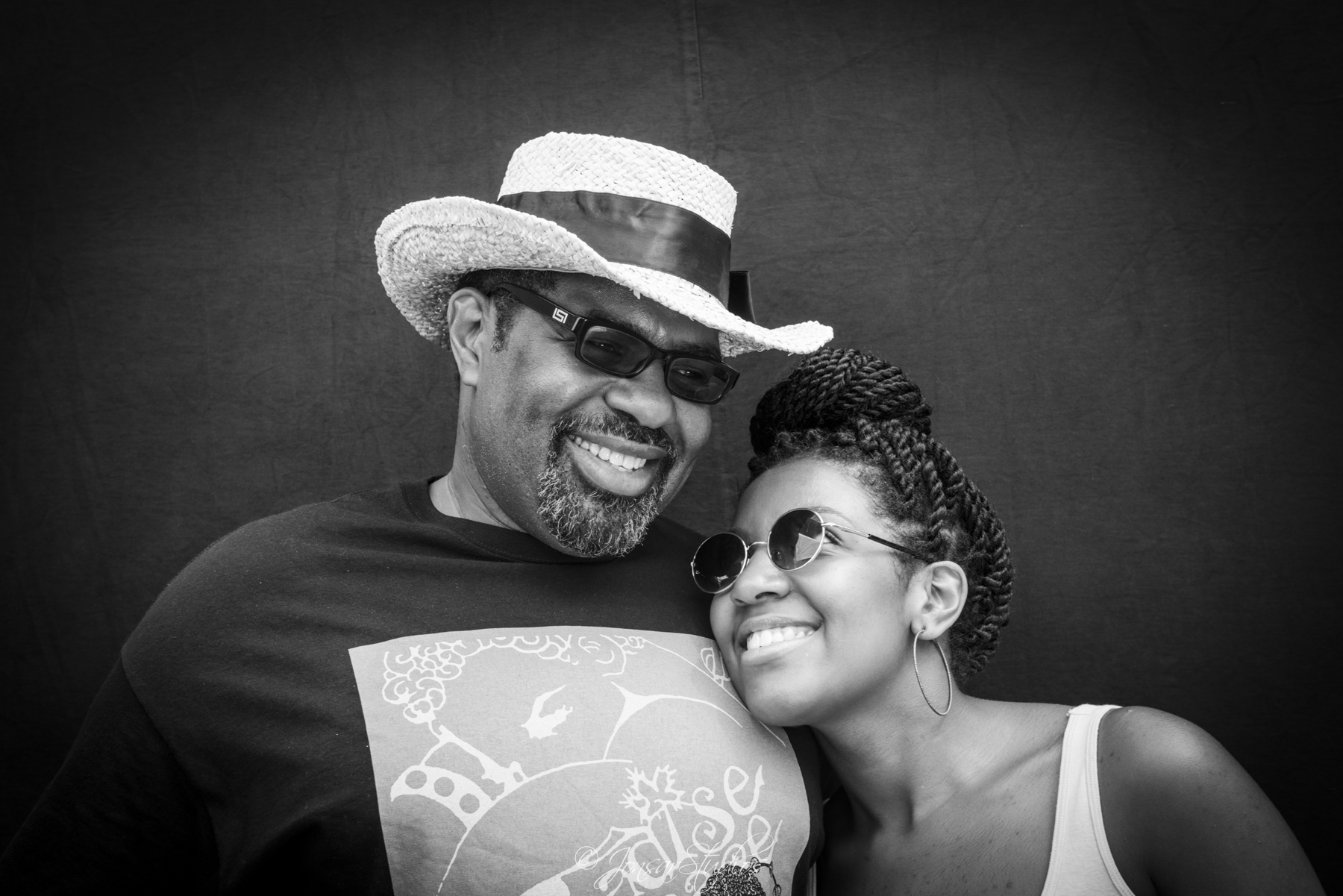 African American father and daughter photographed on black background