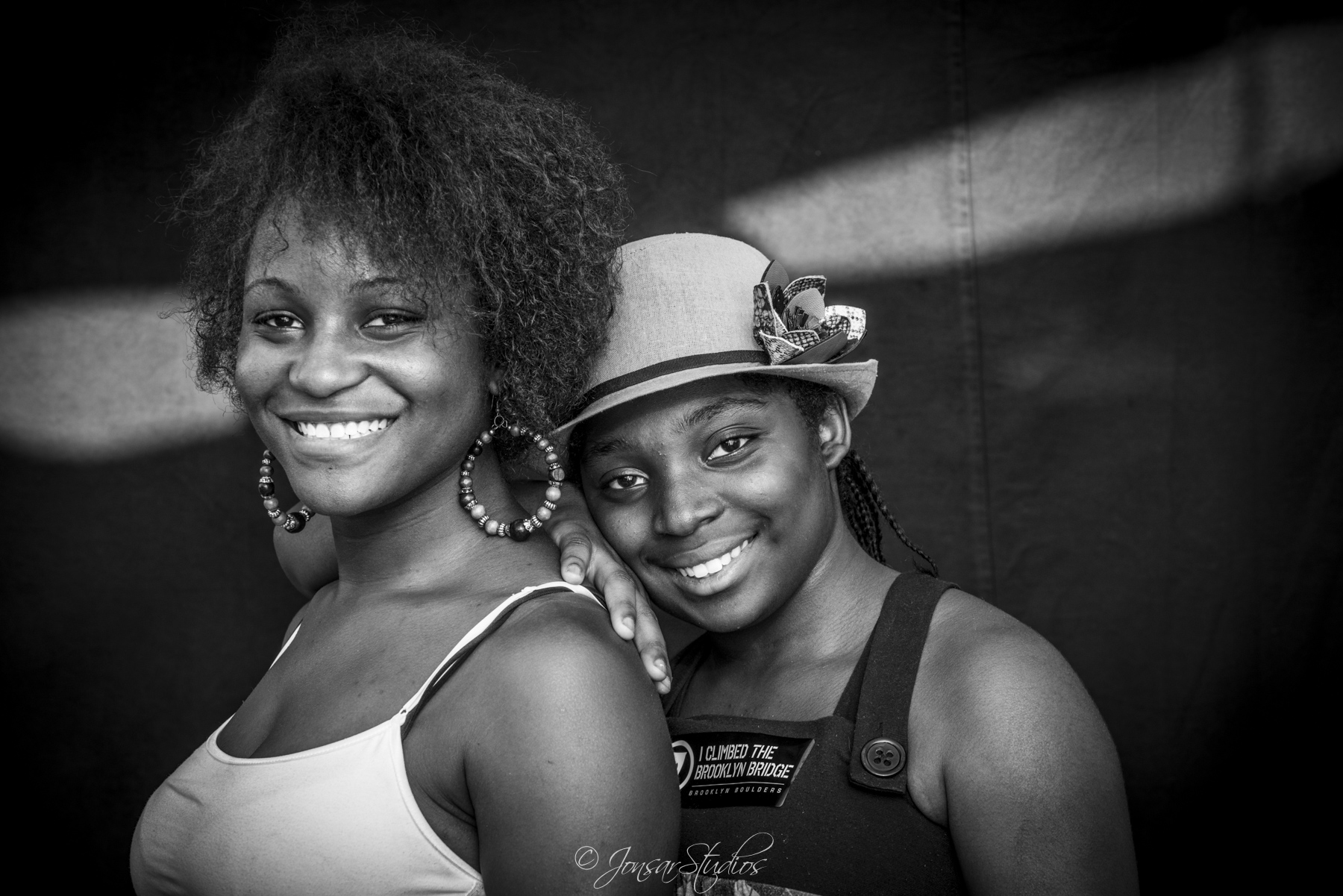 Smiling sisters photographed on black background