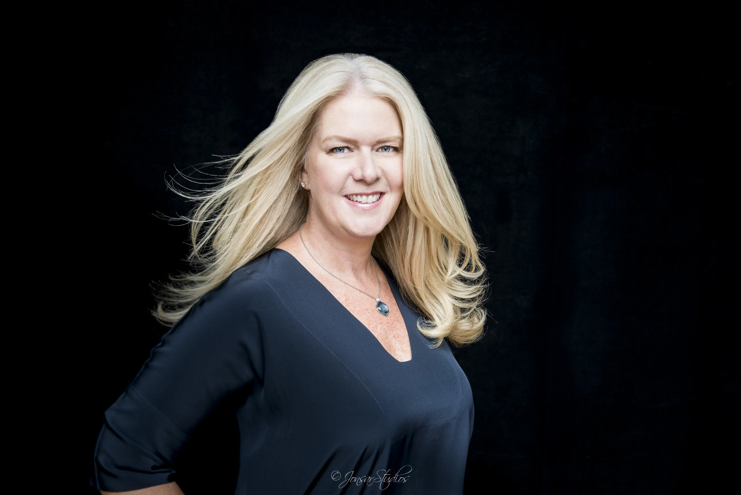 Color corporate portrait of blonde woman on black background