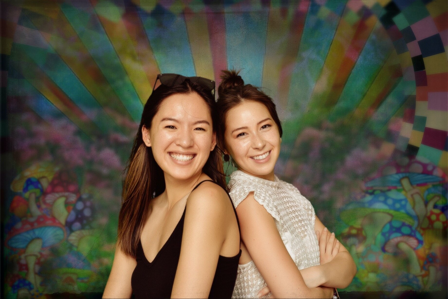Two smiling girls on colorful backdrop