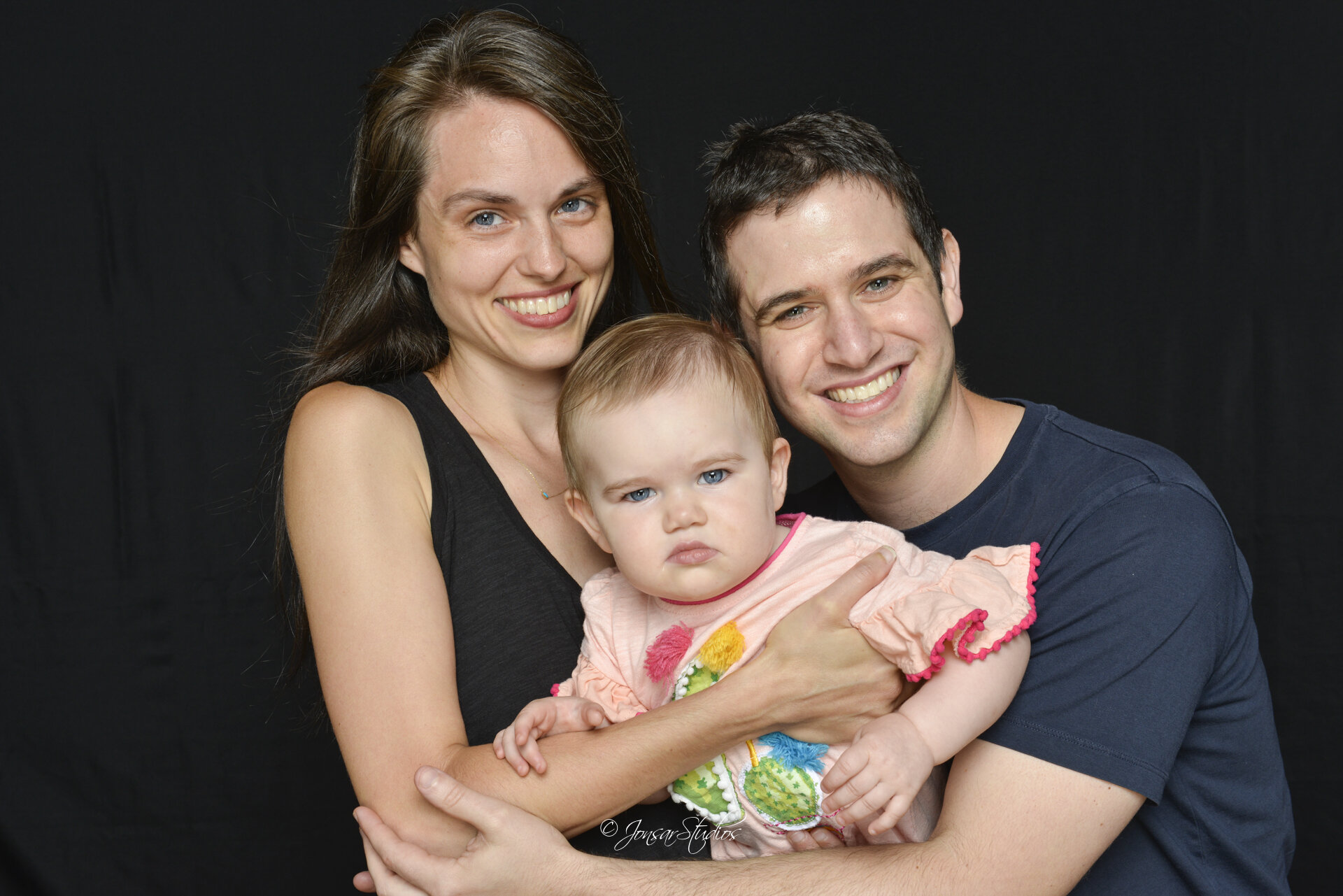 Young Couple with toddler on black background