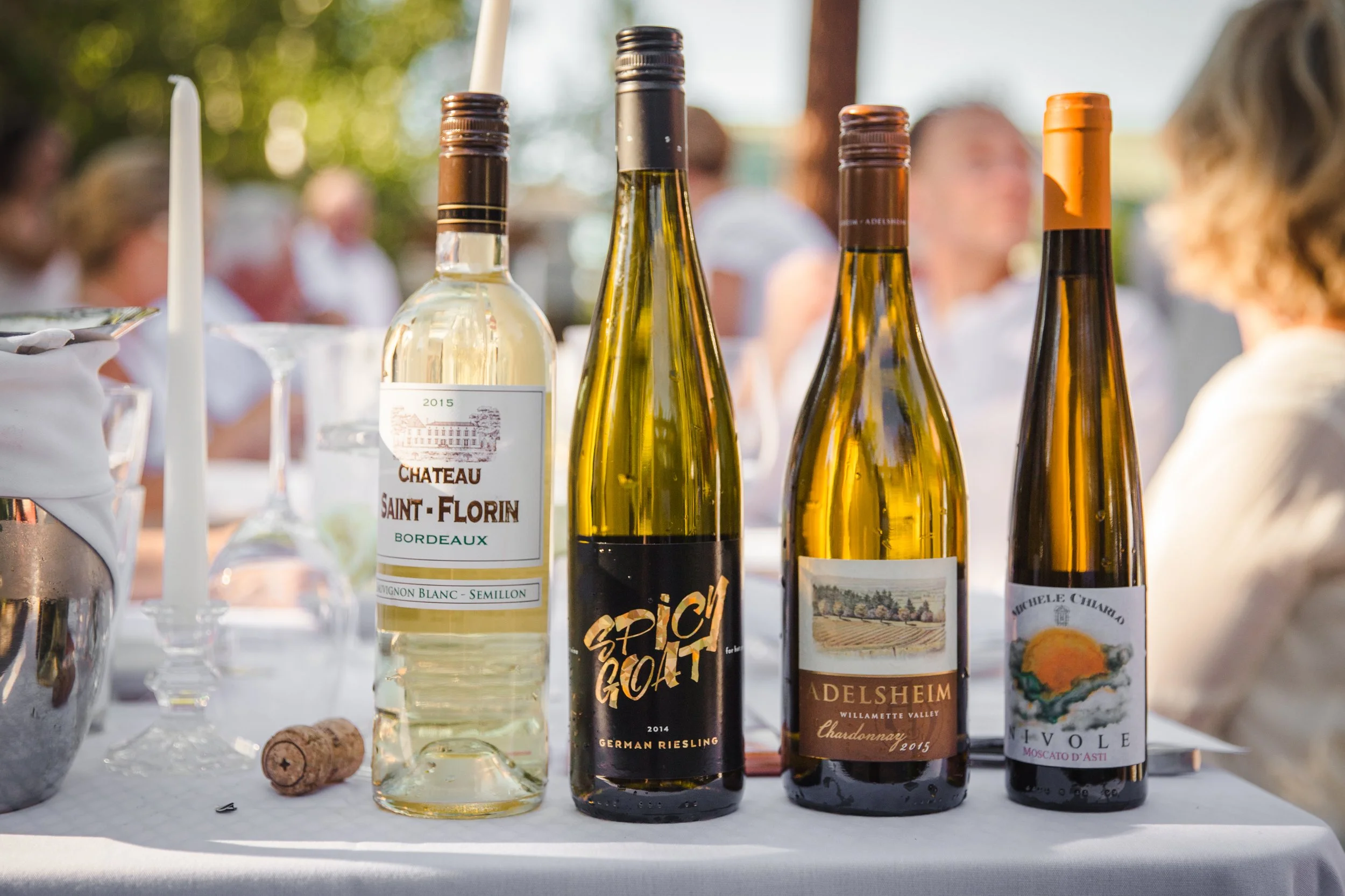 A display of specialty wines served at a summer dinner in white event