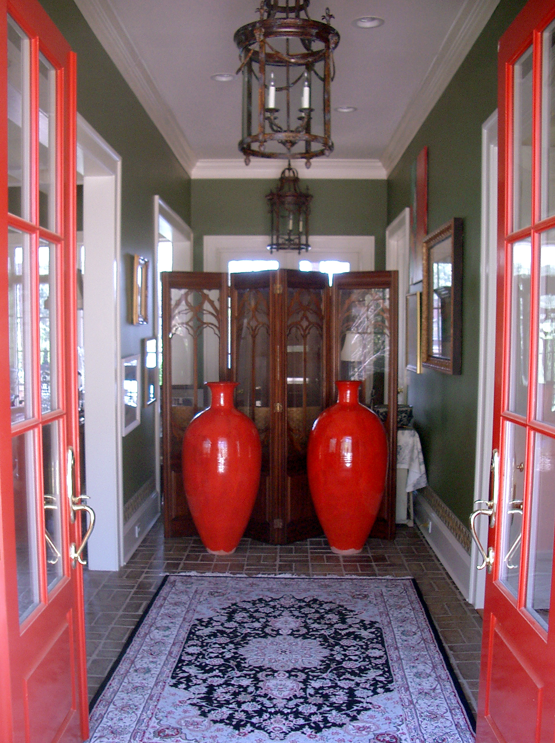   Two tall Chinese Red vases by Ben Owen III grace the entryway of home.  