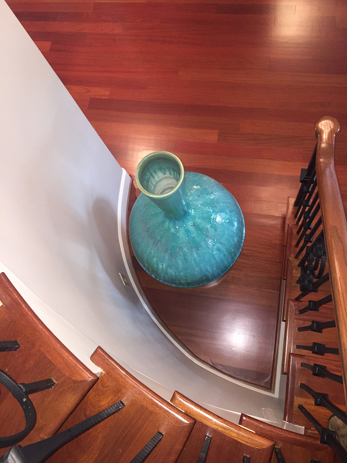   A large Patina Green vase compliments the dramatic stairwell in the home of these collectors.  