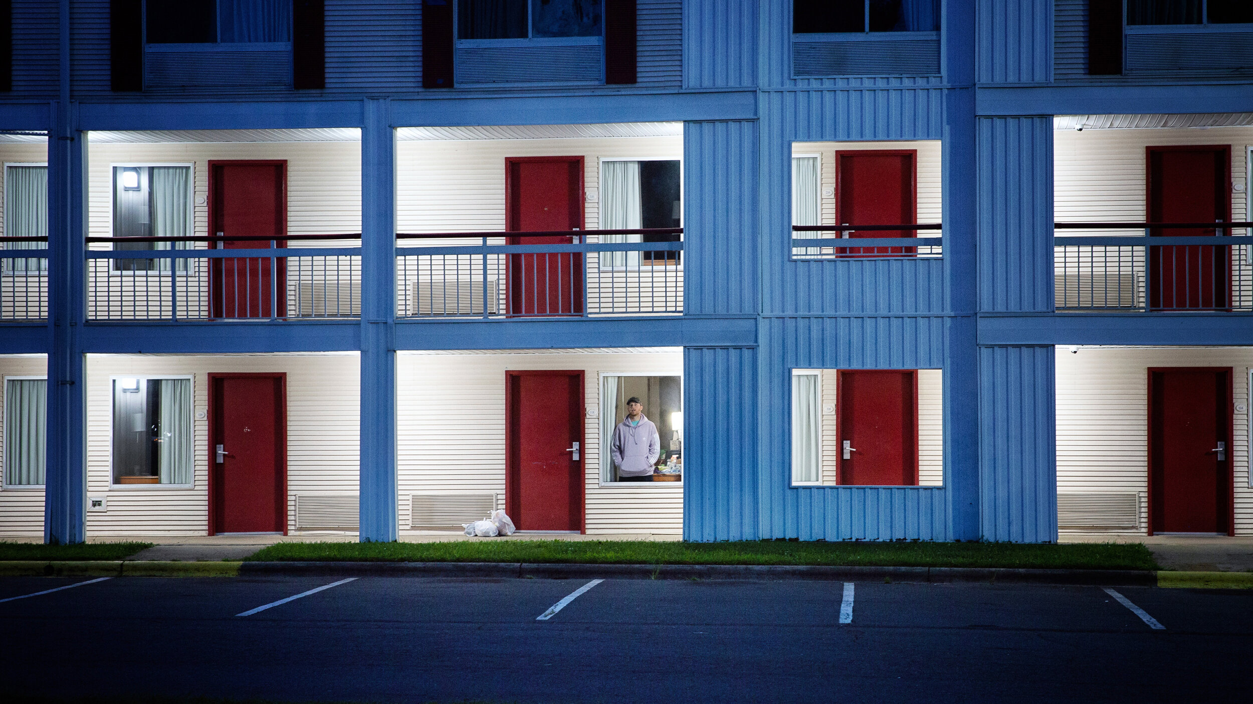  Aaron Hall, 32 of Kansas City, looks out a window of the Econo Lodge near the Charlotte Douglas International Airport in Charlotte, N.C., where he stayed 10 days and nine nights after testing positive for COVID-19. Hall had traveled to Charlotte fro