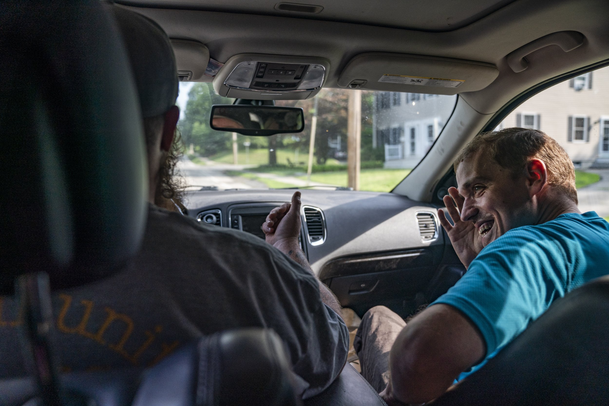 Charlie Palmer, a daytime staff member with Shared Life Collaborative, makes Andy Tranfaglia laugh while driving around West Newbury, Monday, June 21, 2021.