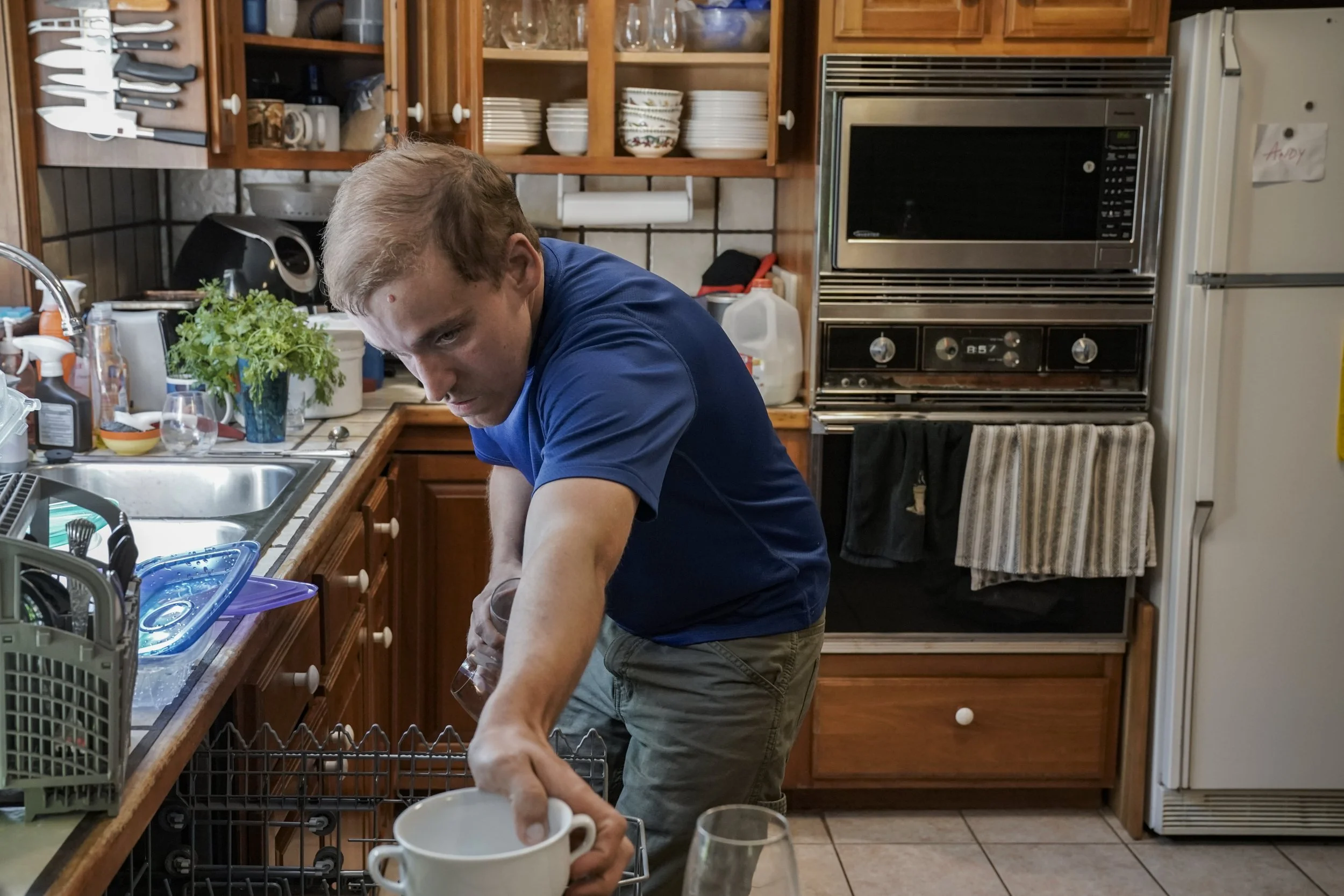  In the morning before going to his day program, Andy Tranfaglia empties the dishwasher at his parent’s request.  