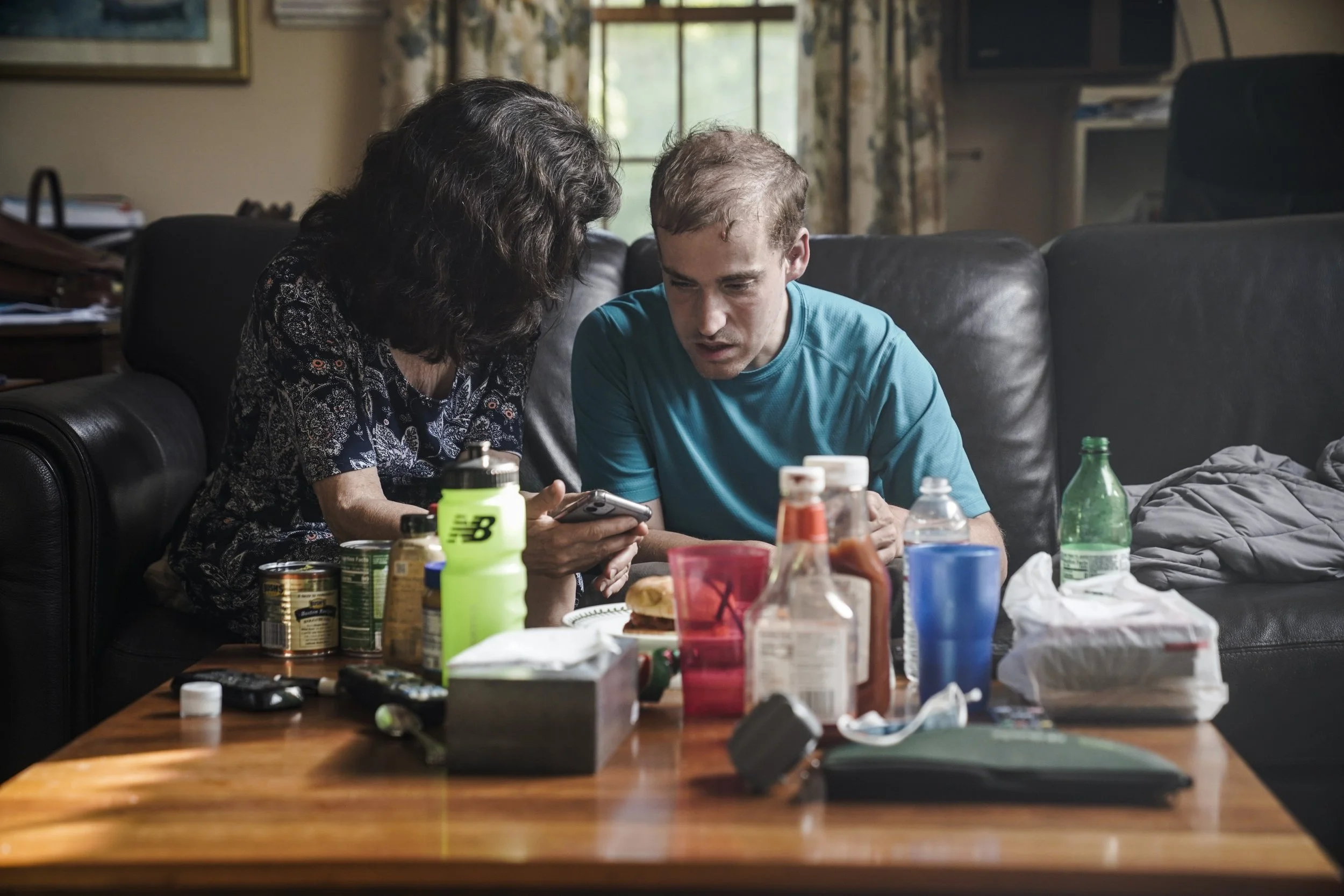  Katie Clapp sits with Andy to make a call before eating dinner.  
