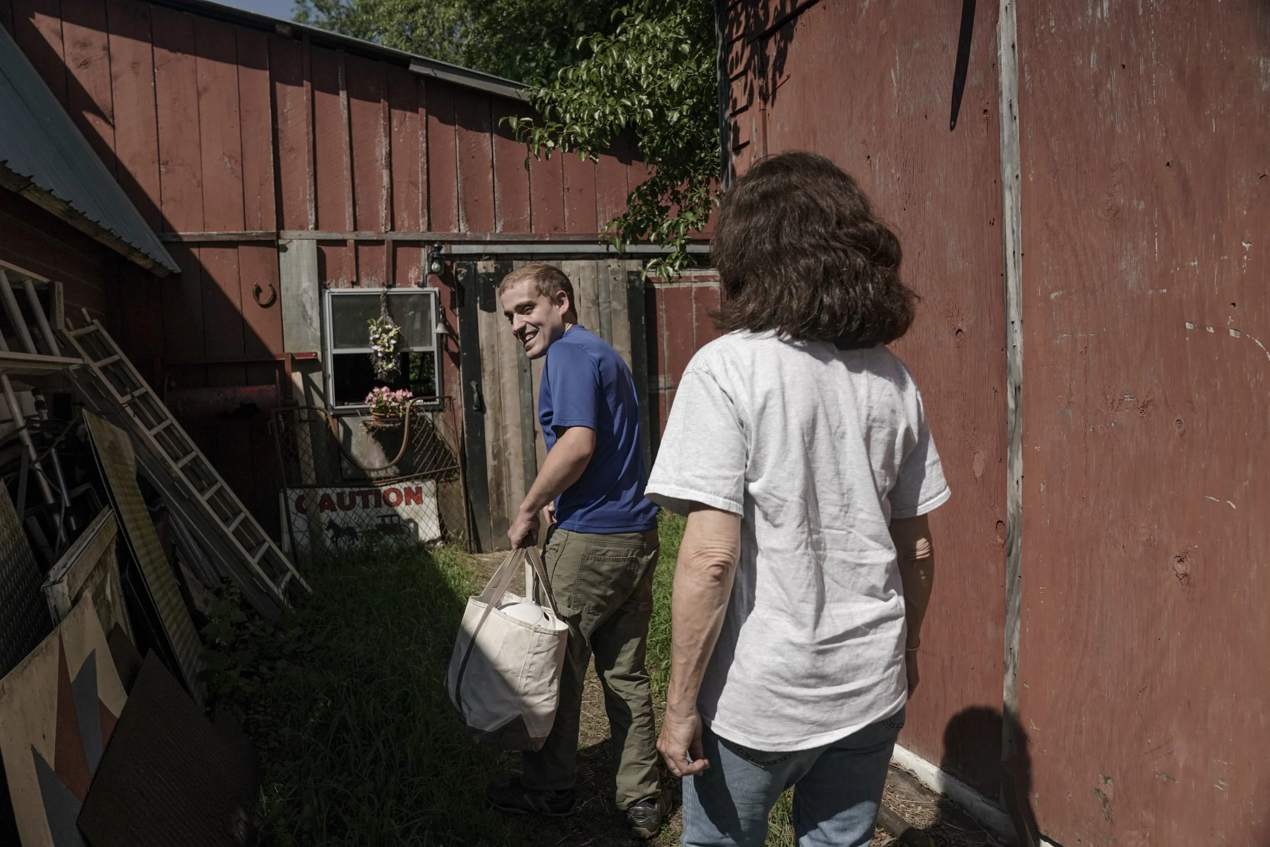  Andy Tranfaglia smiles back at his mother, Katie Clapp, as she drops him off at a barn for work through his day program with Shared Living Collaborative on June 20 in West Newbury, Mass. 