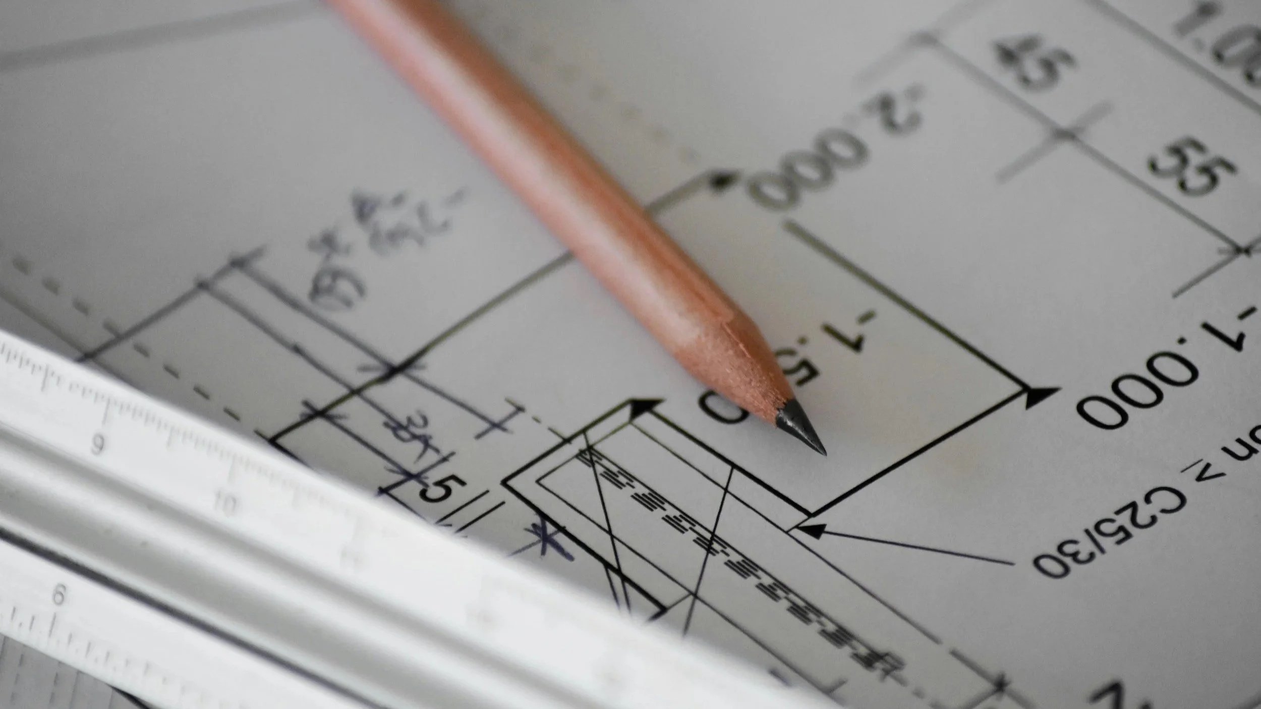 Grundrisszeichnung mit Bleistift und Lineal – Symbol für die Grundrissanalyse in der Interior‑Projektplanung.