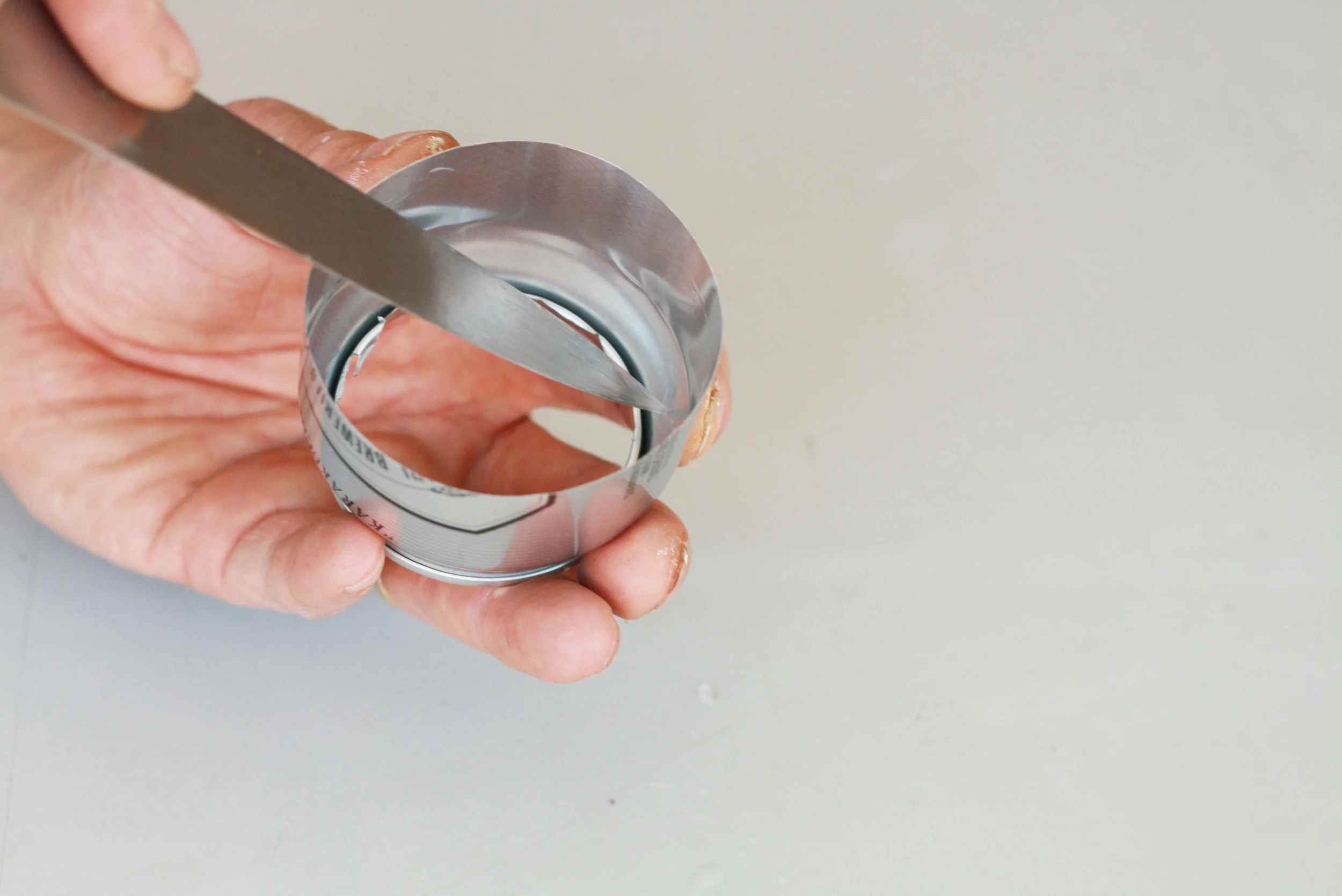 From the inside of the can with a knife pierce a tiny hole for air intake.