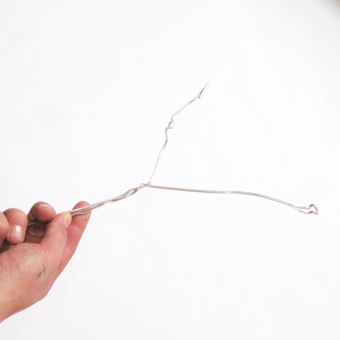 Form a twist at the split end of the coat hanger to make a Y shape